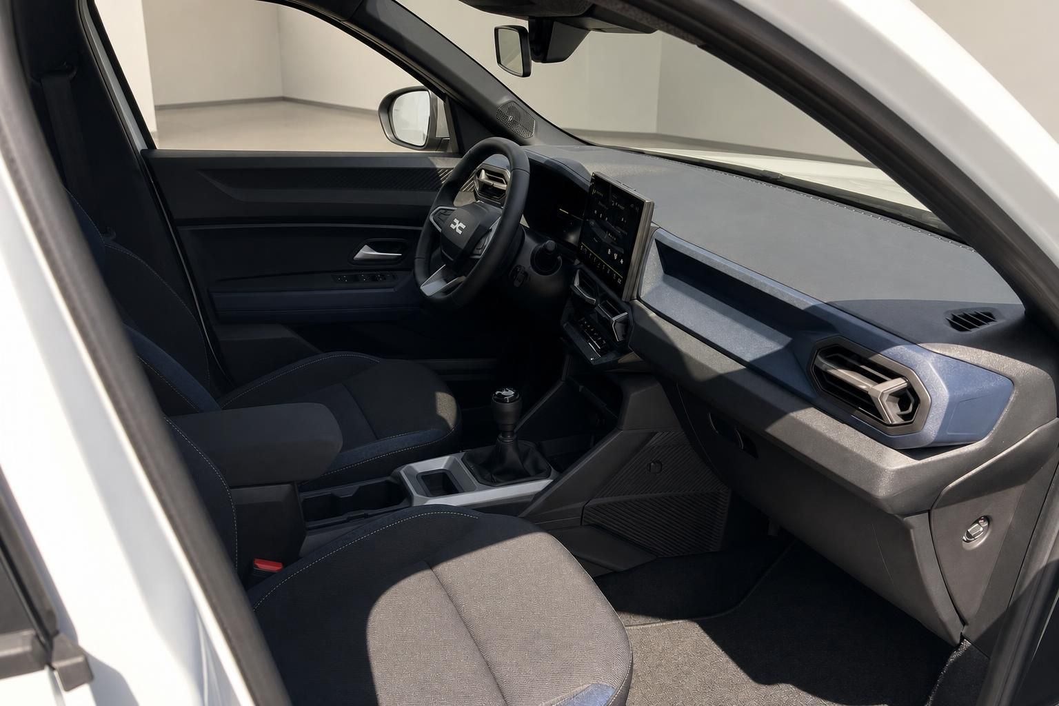 Innenraum Dacia mit Cockpit, Lenkrad und Schaltung in Schwarz-Grau