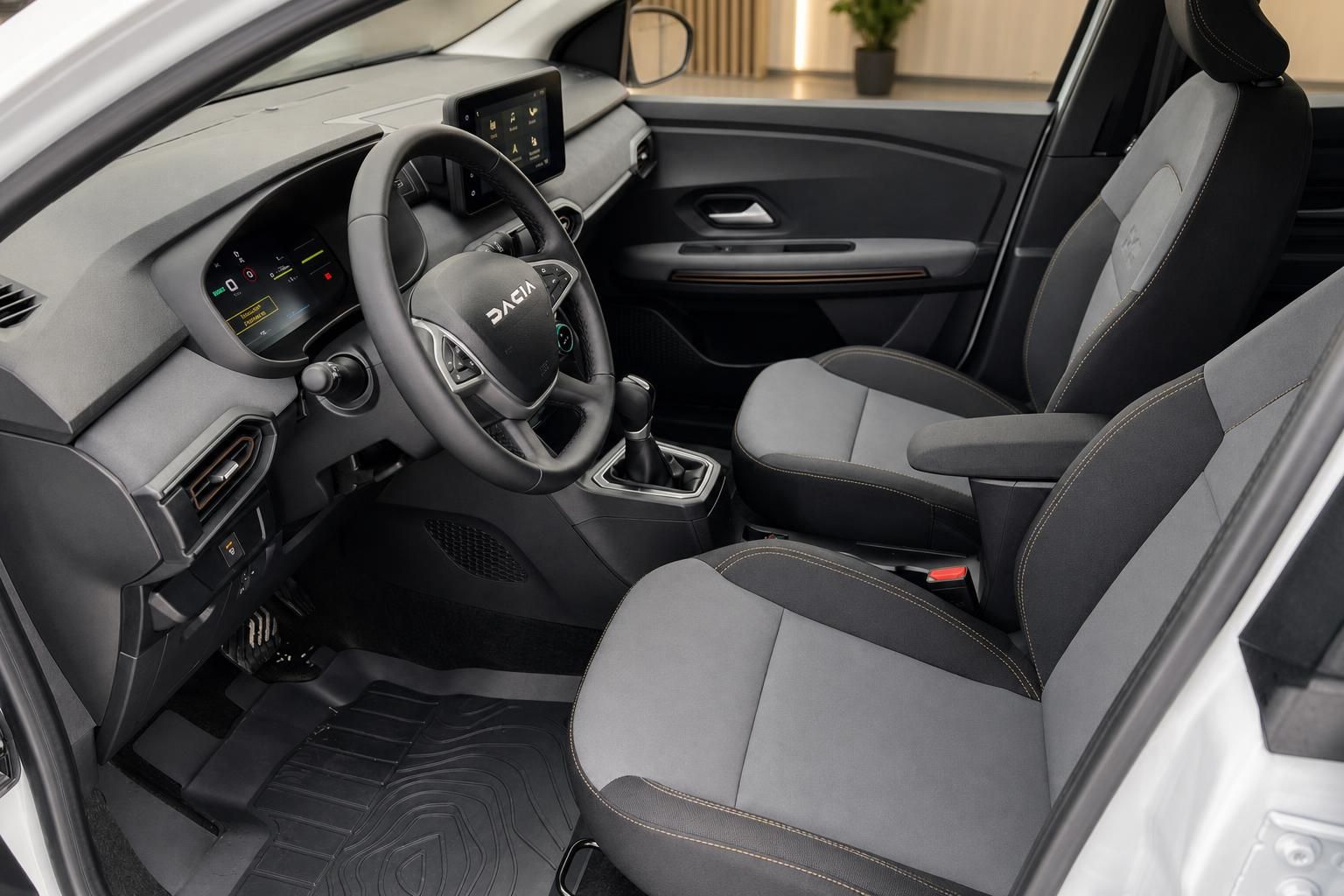 Dacia Innenraum mit grau-schwarzer Ausstattung, Lenkrad und Mittelkonsole mit Touchscreen