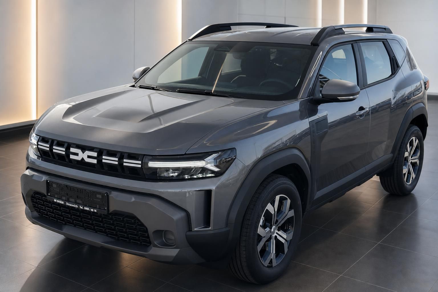 Dacia Duster SUV grau Metallic Frontansicht schräg links mit schwarzem Dach im Showroom
