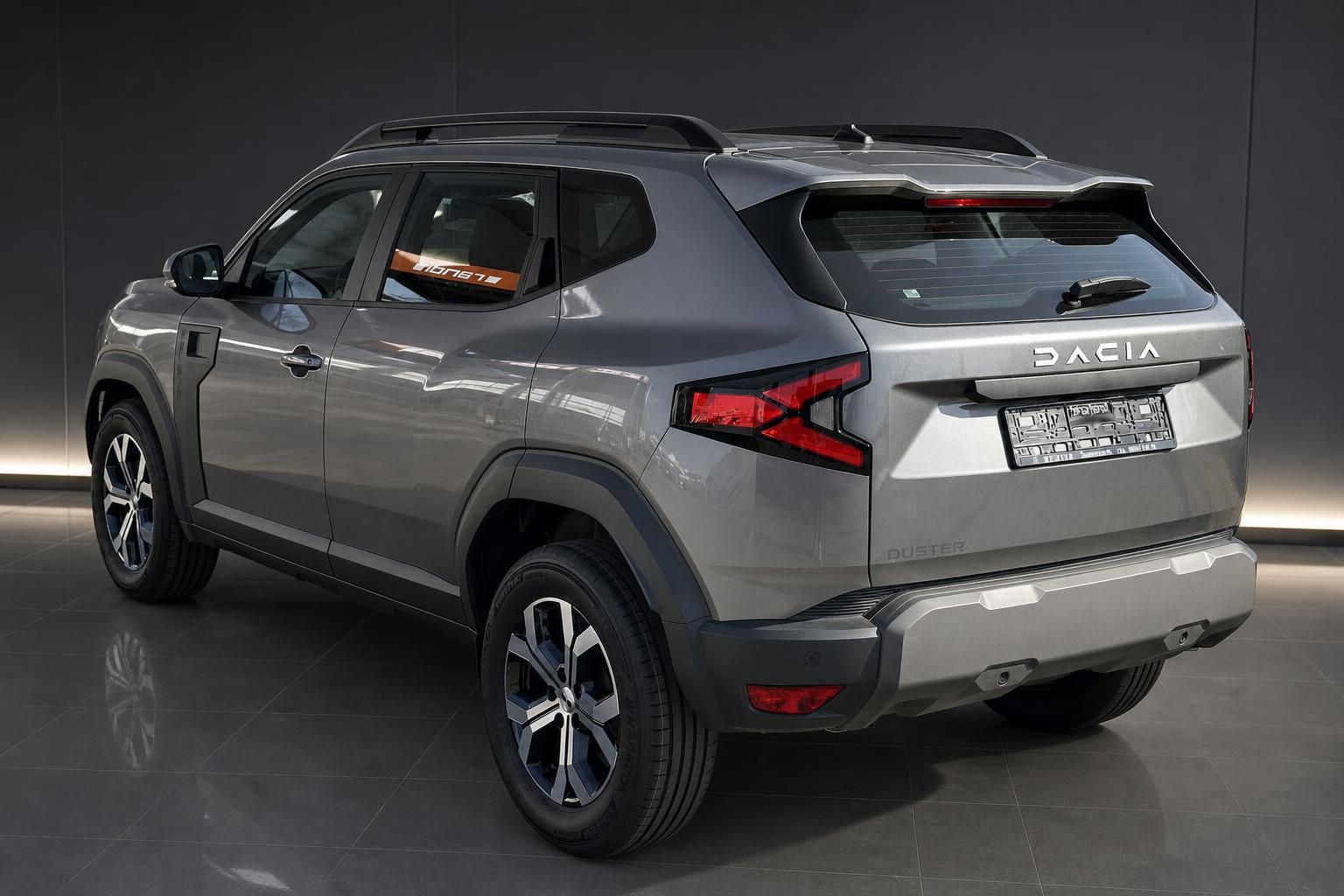 Dacia Duster SUV grau Heckansicht schräg im Showroom mit Dachreeling und LED-Rückleuchten