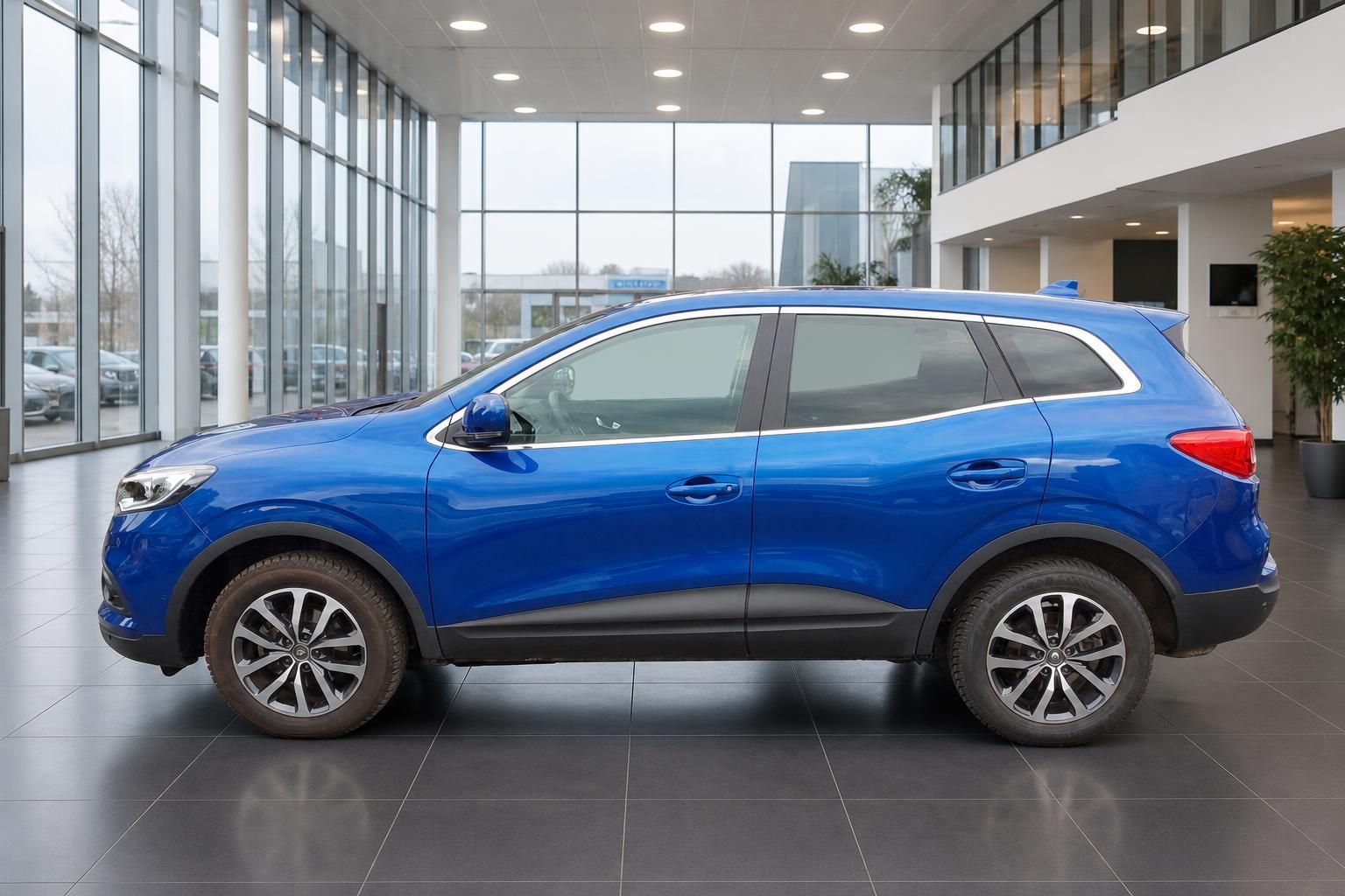 Blauer Renault Kadjar SUV Seitenansicht im Autohaus-Showroom