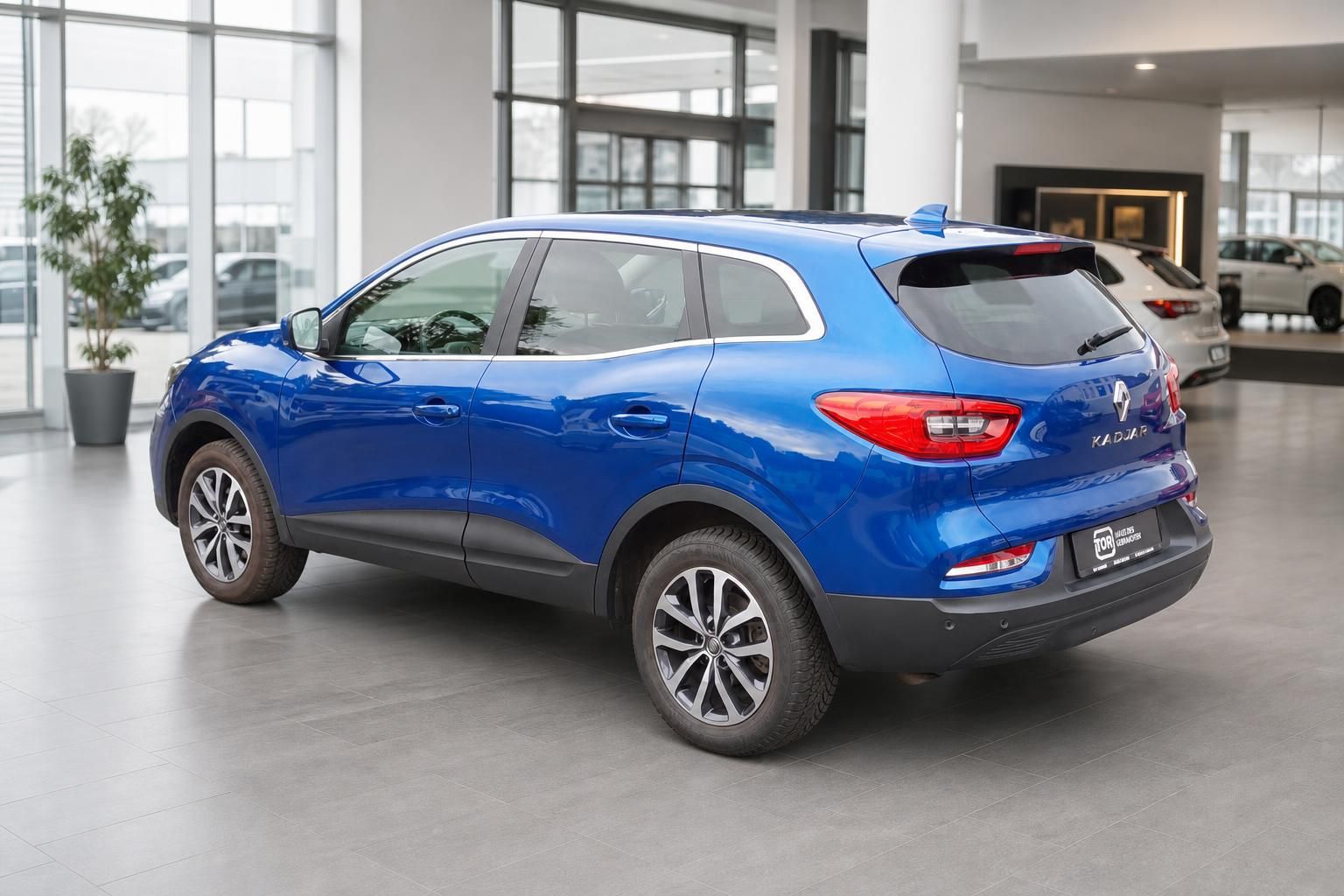Blauer Renault Kadjar von hinten links im Autohaus