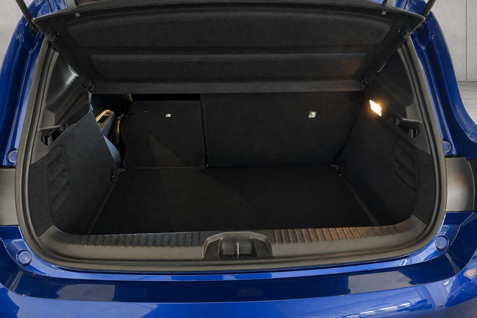 Offener Kofferraum mit umgeklappten Rücksitzen im blauen Auto