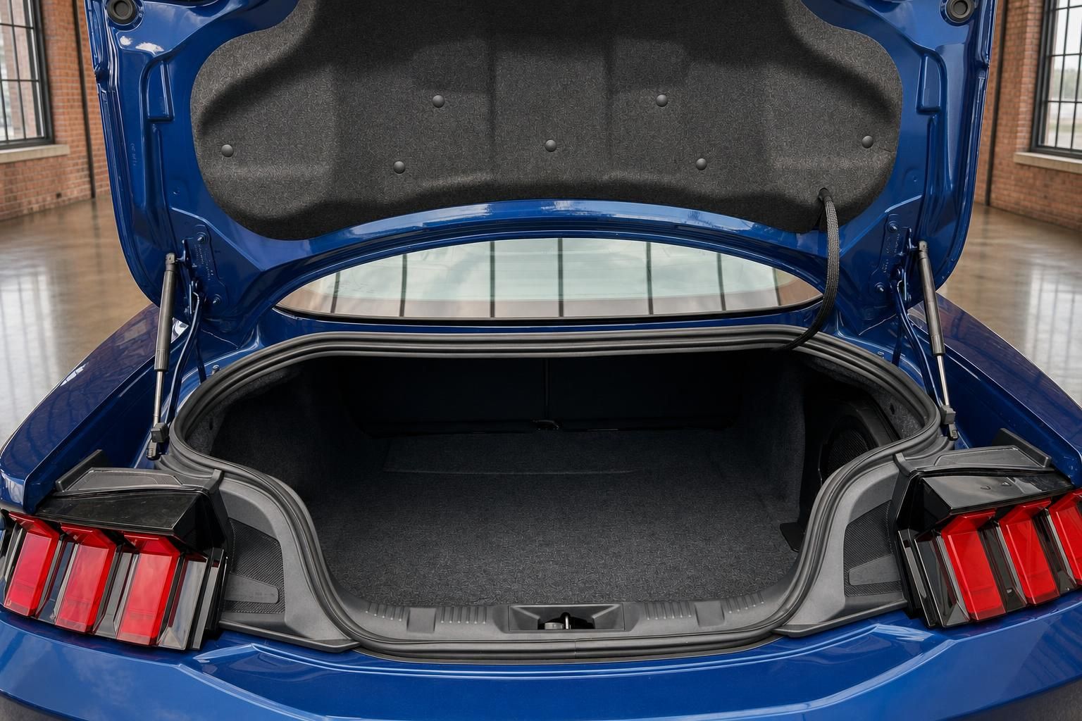 Ford Mustang blau – geöffneter Kofferraum mit Teppichauskleidung und LED-Rückleuchten