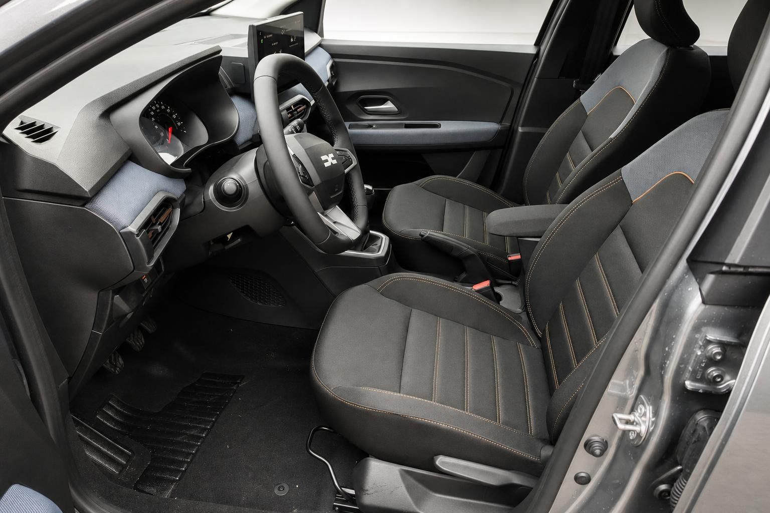 Dacia Sandero Innenraum - schwarze Sitze mit orangenen Akzenten, Lenkrad und Armaturenbrett