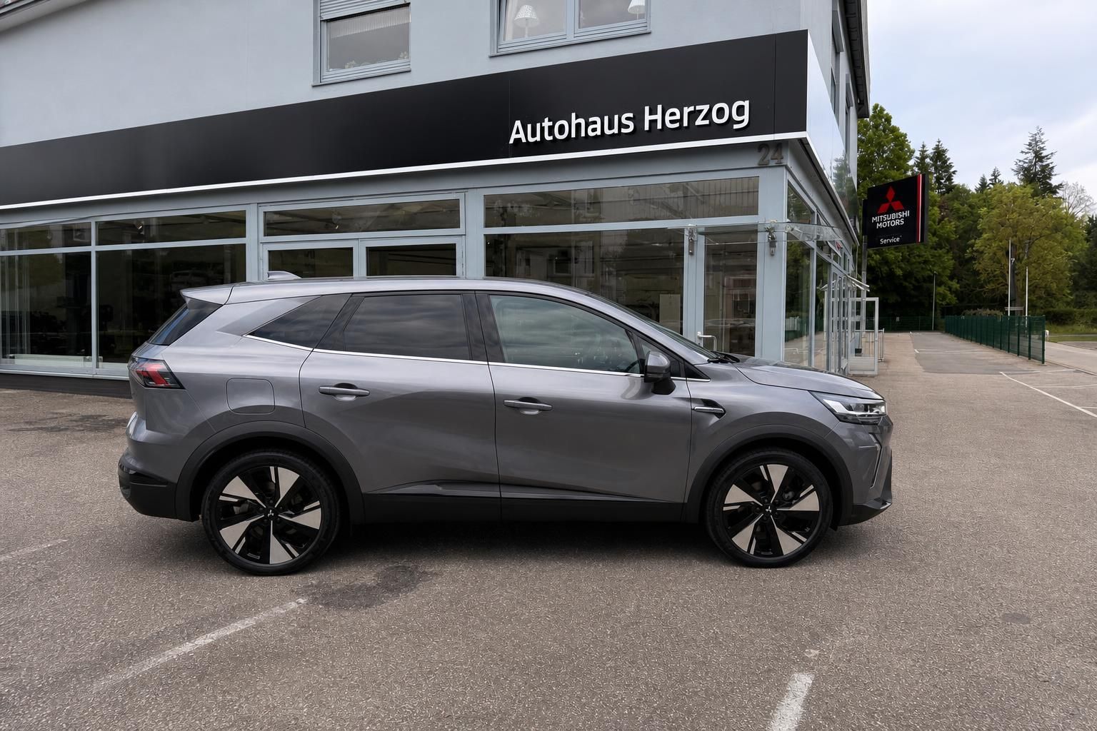 Grauer SUV Seitenansicht vor Autohaus Herzog - Fahrzeug bei Autohändler
