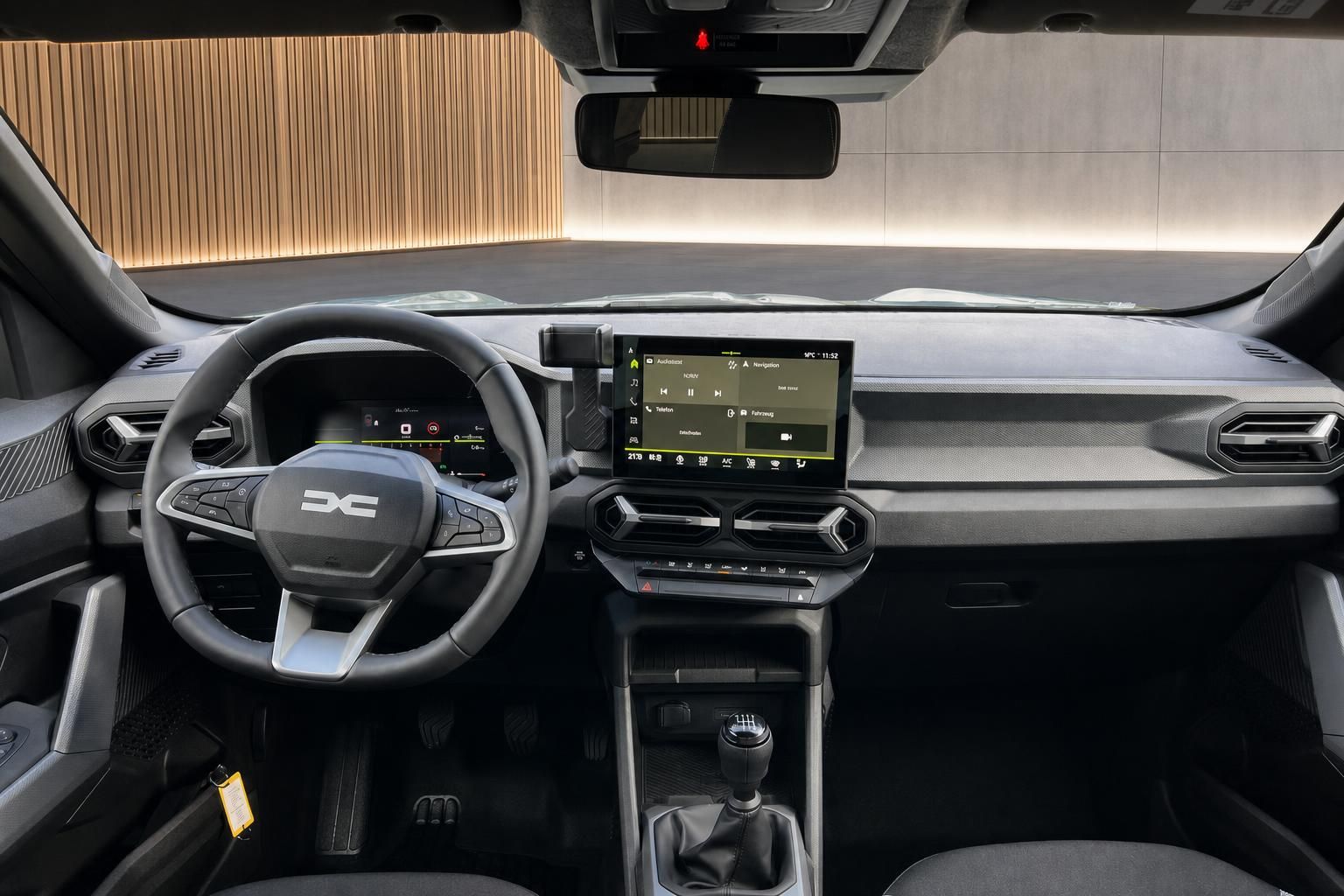 Dacia Cockpit Innenansicht mit Multifunktionslenkrad, Touchscreen und Schaltknauf in dunklem Design
