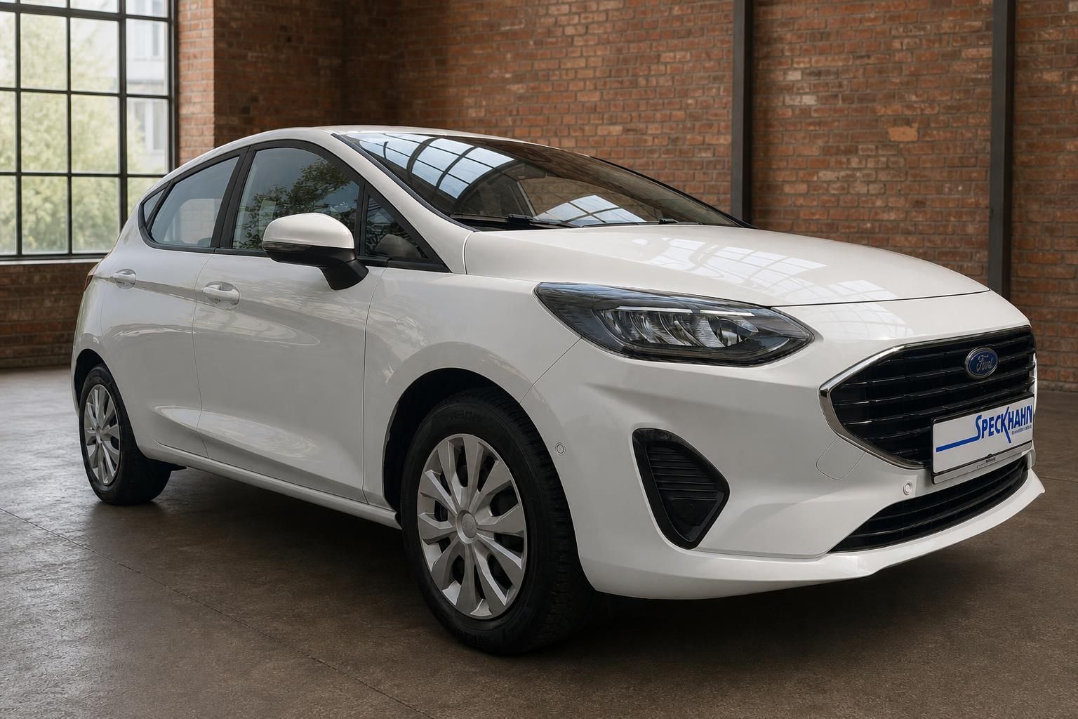 Ford Fiesta weiß Frontansicht seitlich vor Backsteinwand