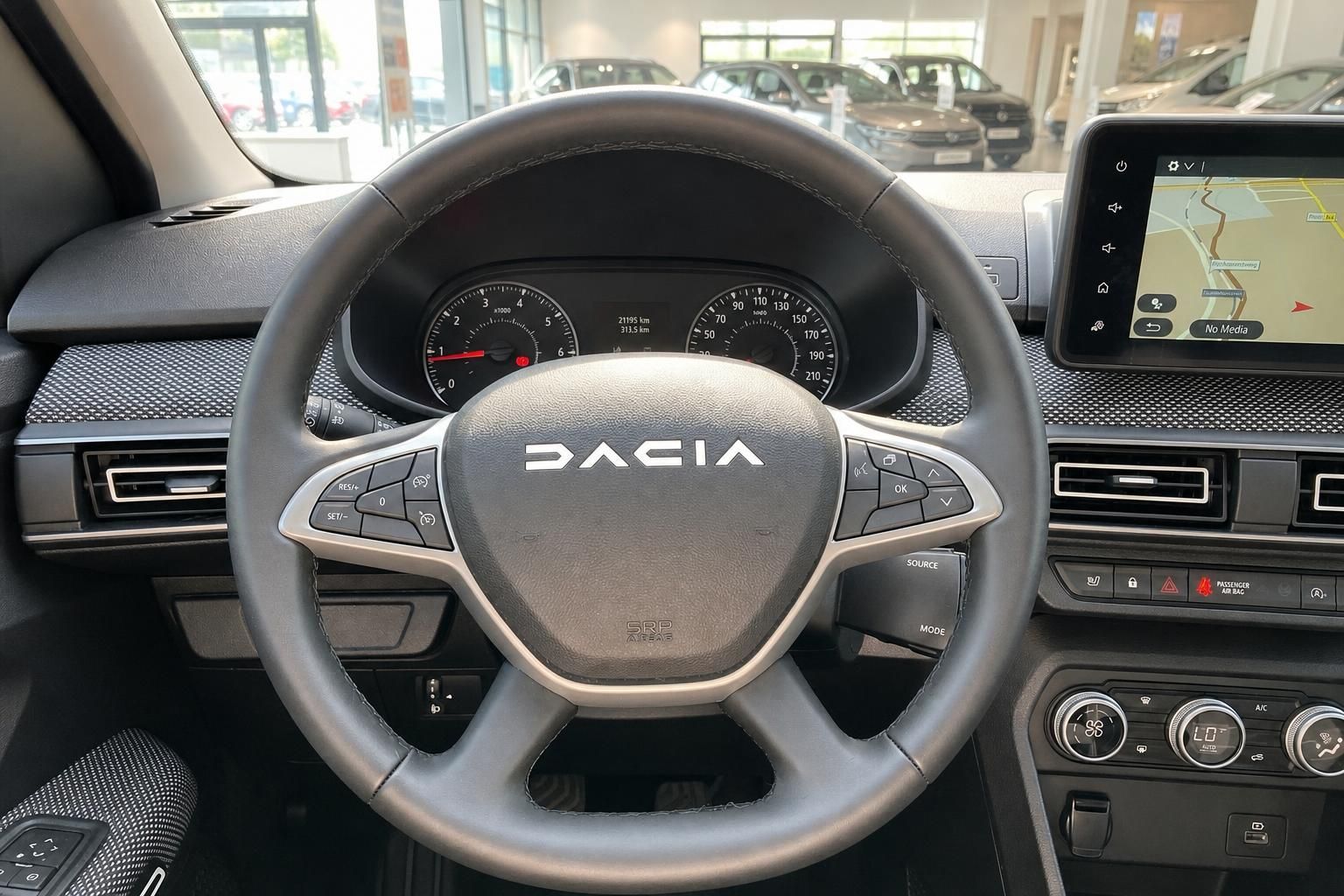 Dacia Lenkrad mit Logo, Instrumententafel, Navigationssystem und Klimabedienfeld im Innenraum