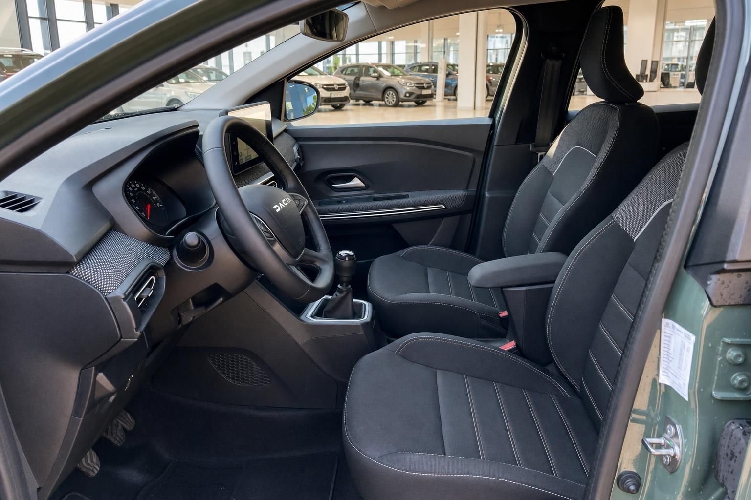 Dacia Innenraum – Fahrersitz, Lenkrad und Mittelkonsole mit Schaltgetriebe im Autohaus
