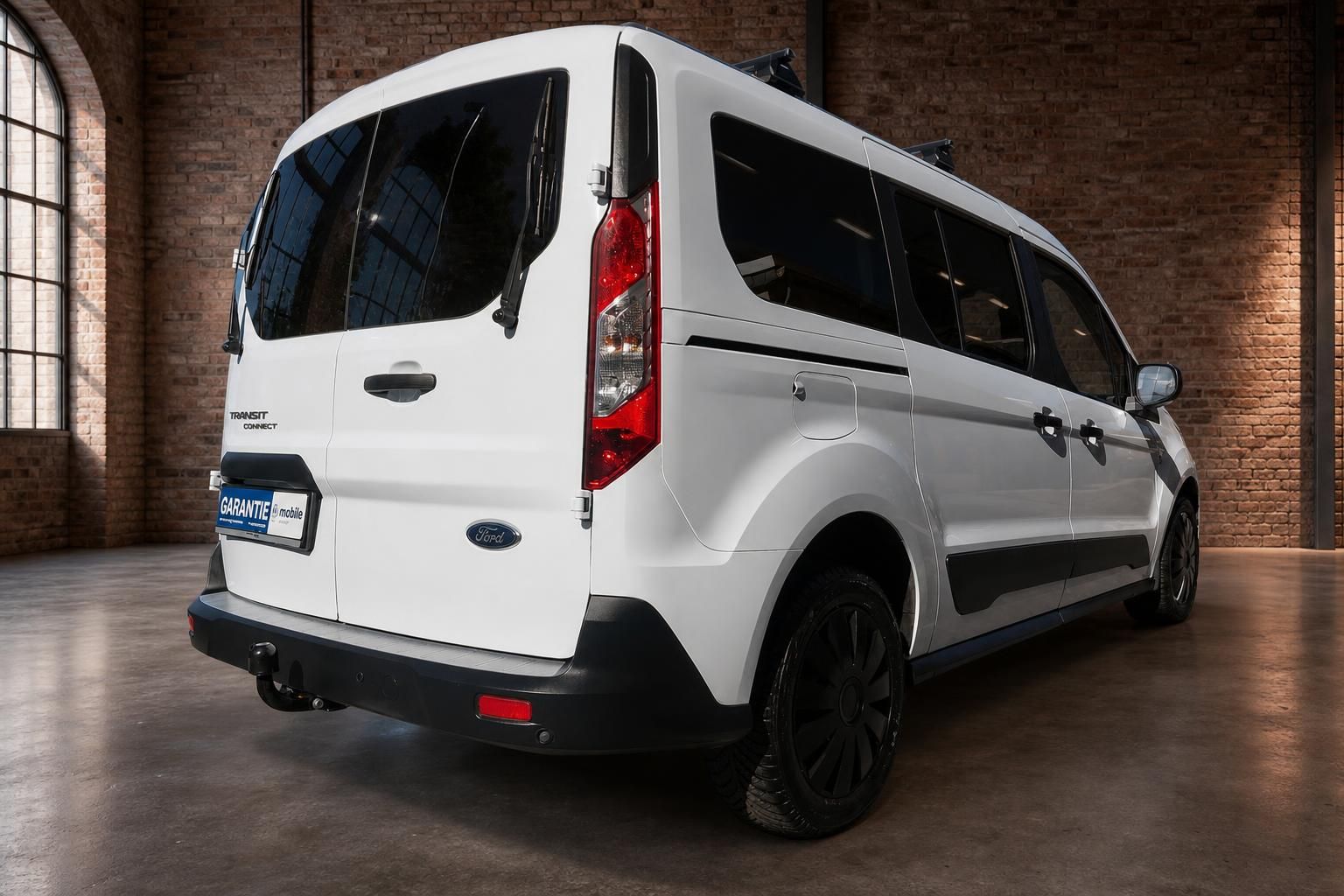 Ford Transit Connect weiss Heckansicht schraeg rechts mit Anhaengerkupplung im Showroom