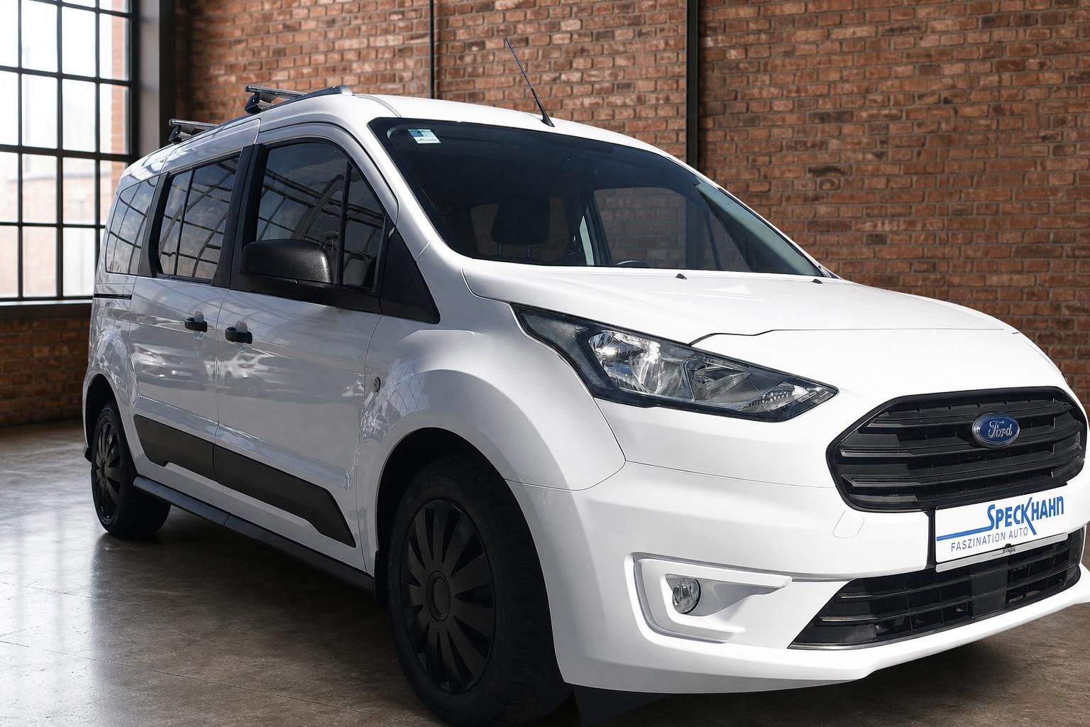 Ford Transit Connect weiss Seitenansicht Front schraeg rechts mit schwarzen Felgen im Showroom