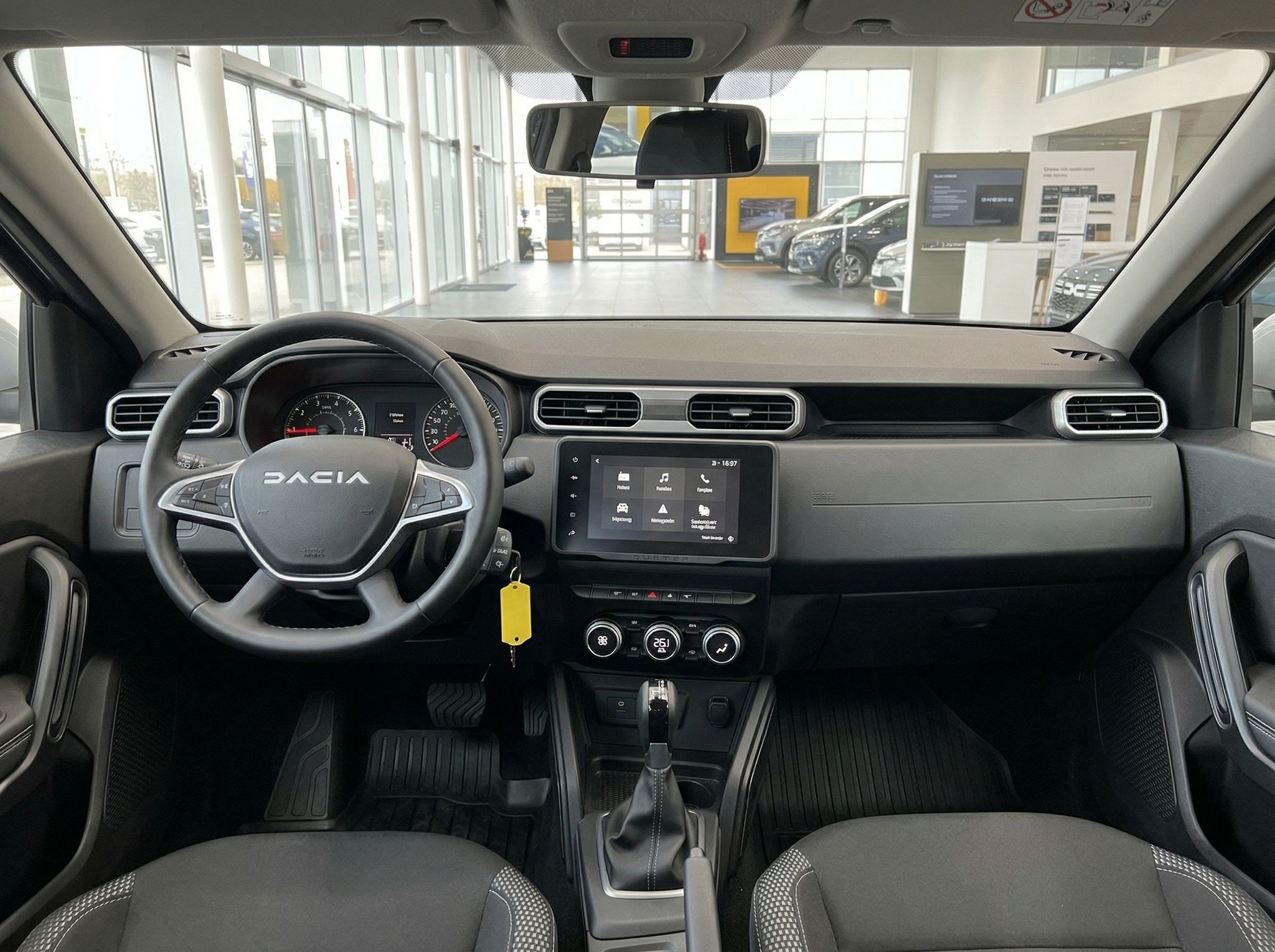 Dacia Innenraum mit schwarzem Lenkrad, Touchscreen-Display und modernem Armaturenbrett