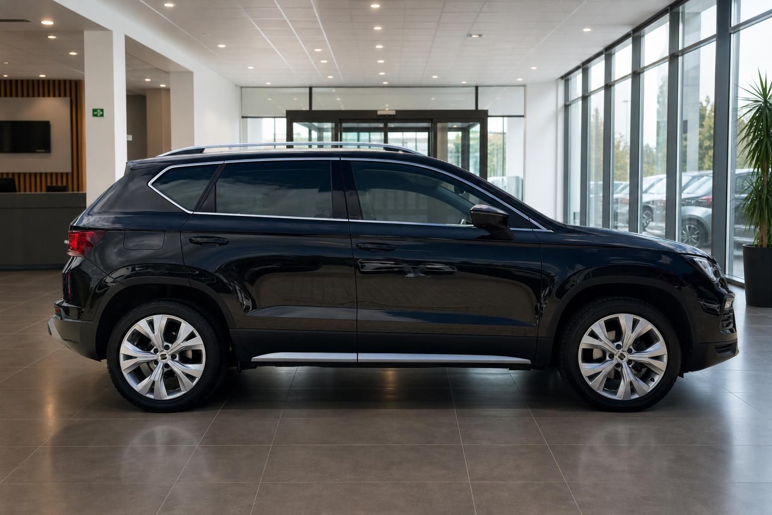 Schwarzer SEAT Ateca Seitenansicht im Autohaus vor Eingang