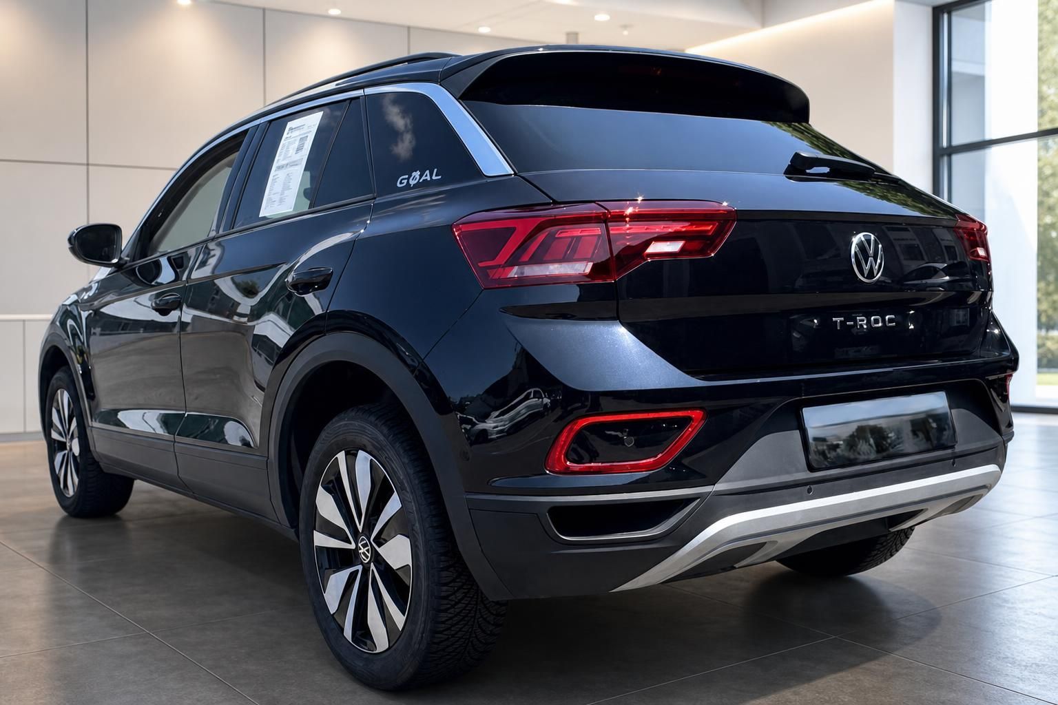 Volkswagen T-Roc GOAL schwarz, seitliche Heckansicht mit Leichtmetallfelgen im Autohaus