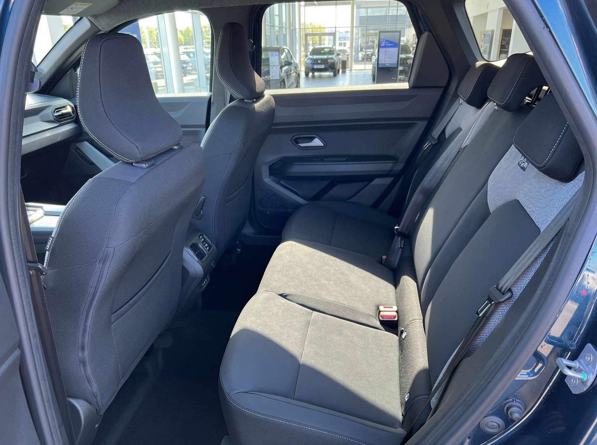 Rücksitzbank eines Fahrzeugs mit Stoffsitzen und Sicherheitsgurten