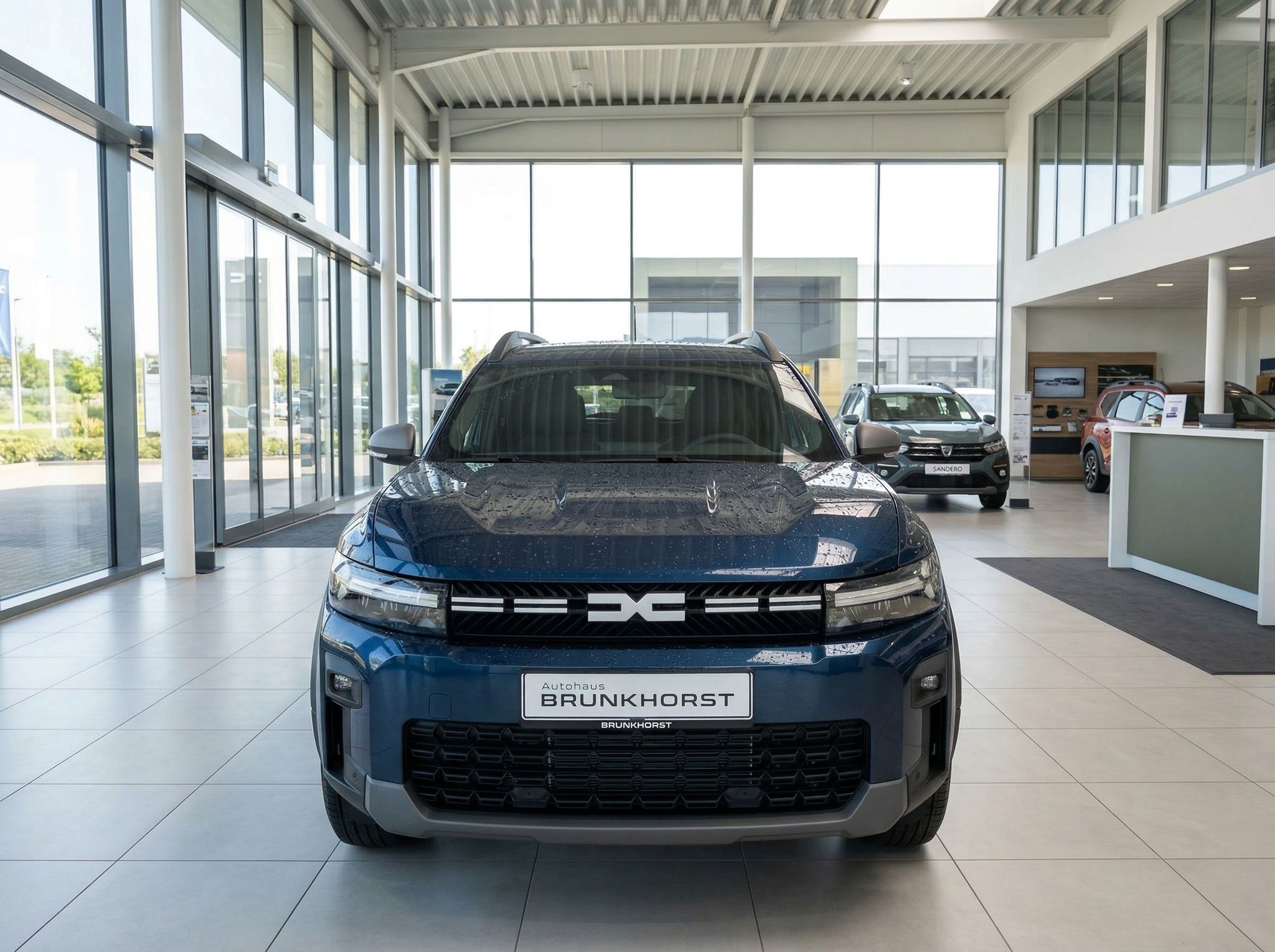 Blauer Dacia SUV Frontansicht im hellen Autohaus-Showroom