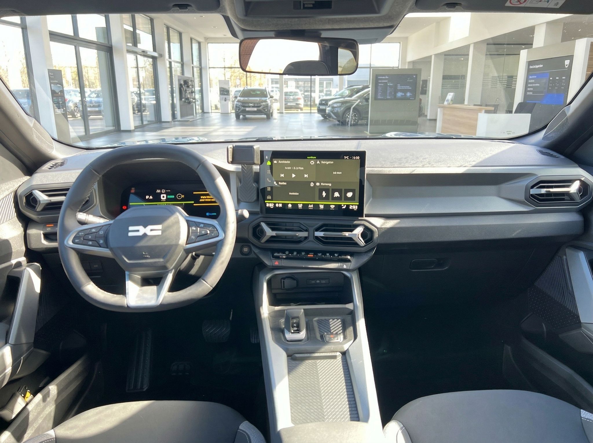 Modernes Fahrzeug-Cockpit mit digitalem Display und Lenkrad im Autohaus-Showroom