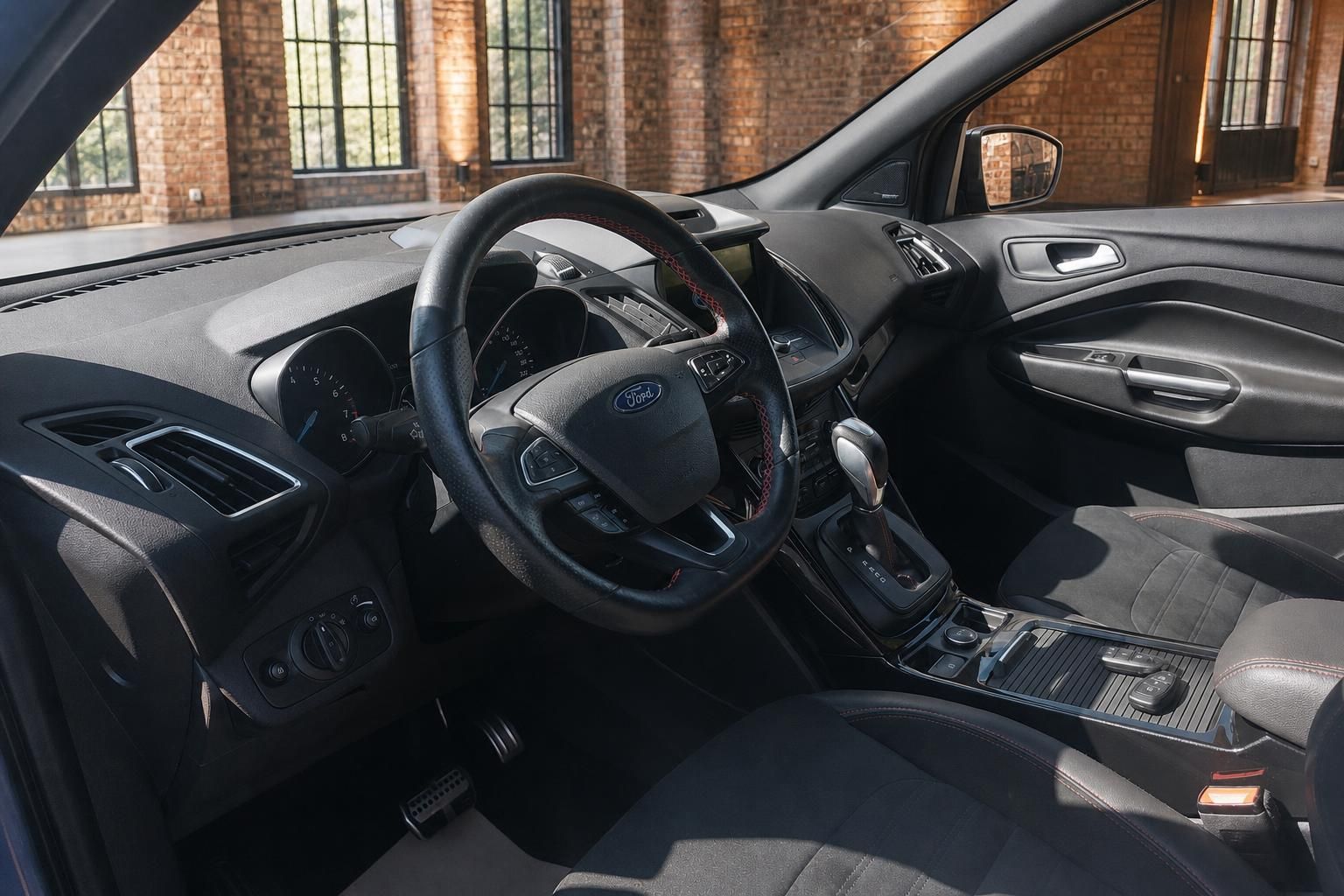 Ford Kuga Innenraum mit Lederlenkrad, Automatikgetriebe und schwarzen Sportsitzen