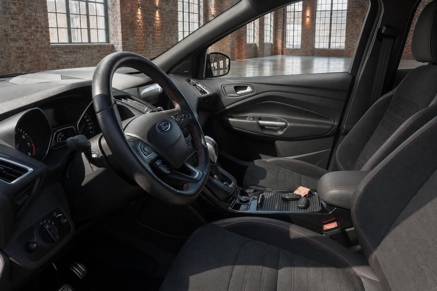 Ford Kuga Innenraum Fahrerseite mit Lenkrad, Mittelkonsole und schwarzen Sportsitzen