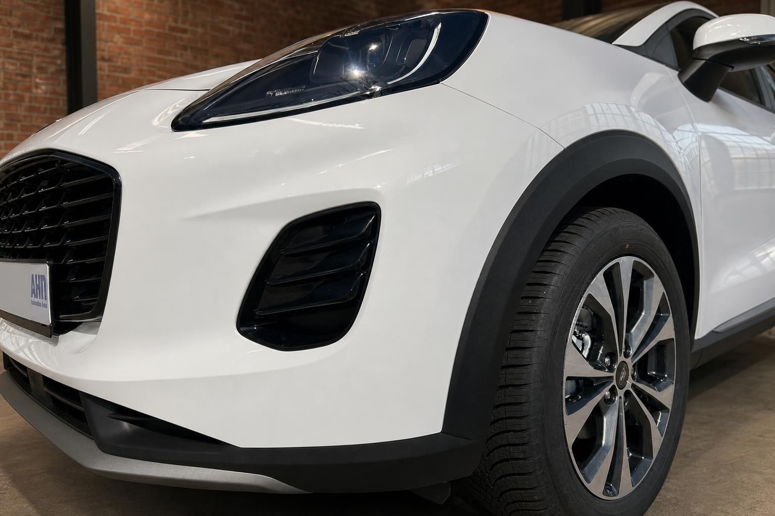 Ford Puma weiss Detailansicht Front links mit Scheinwerfer und Leichtmetallfelge