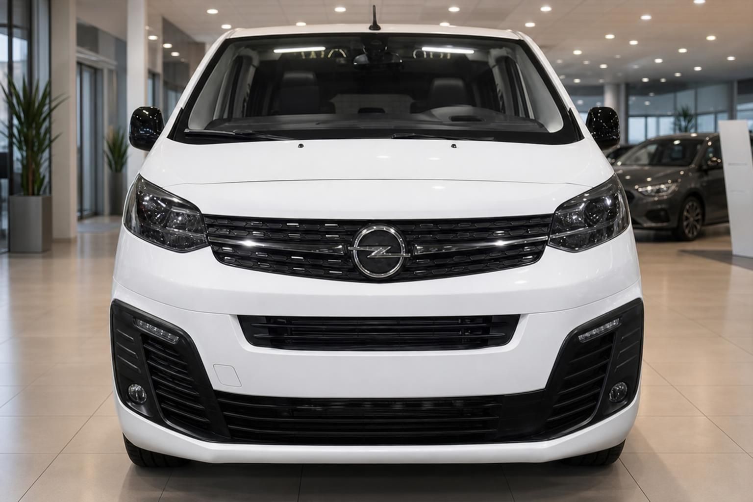 Opel Vivaro weißer Transporter Frontansicht mit Opel-Logo und LED-Tagfahrlicht im Autohaus