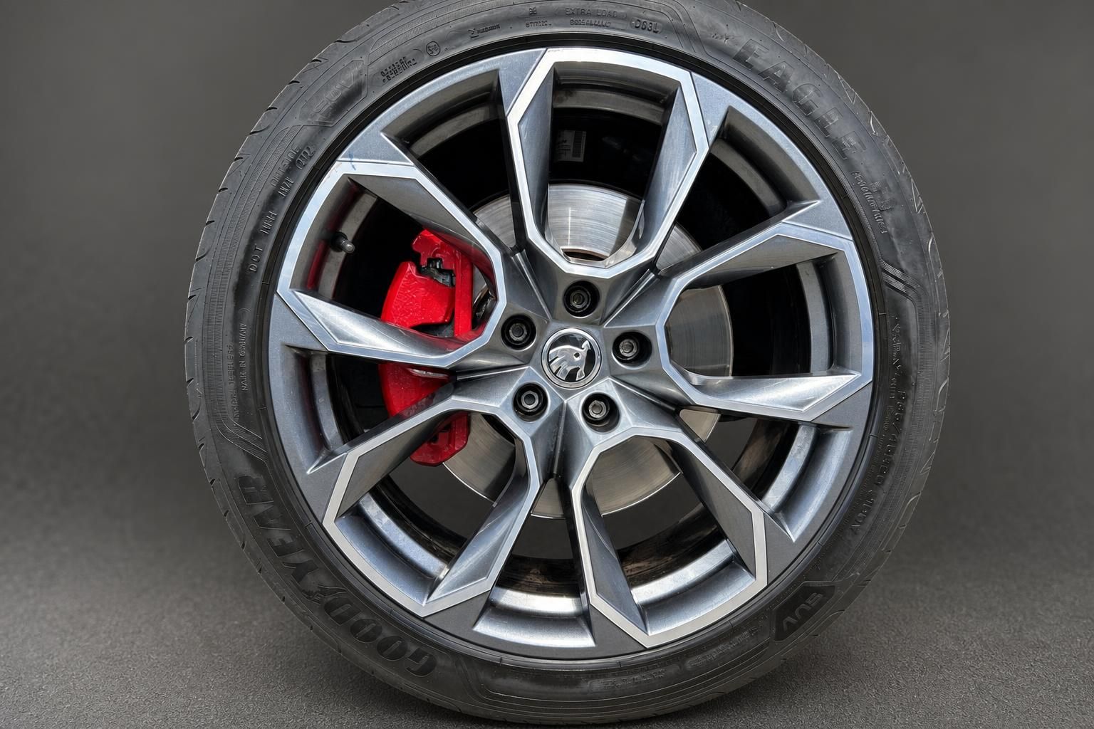 Leichtmetallfelge mit rotem Bremssattel und Goodyear Eagle Reifen im Detail