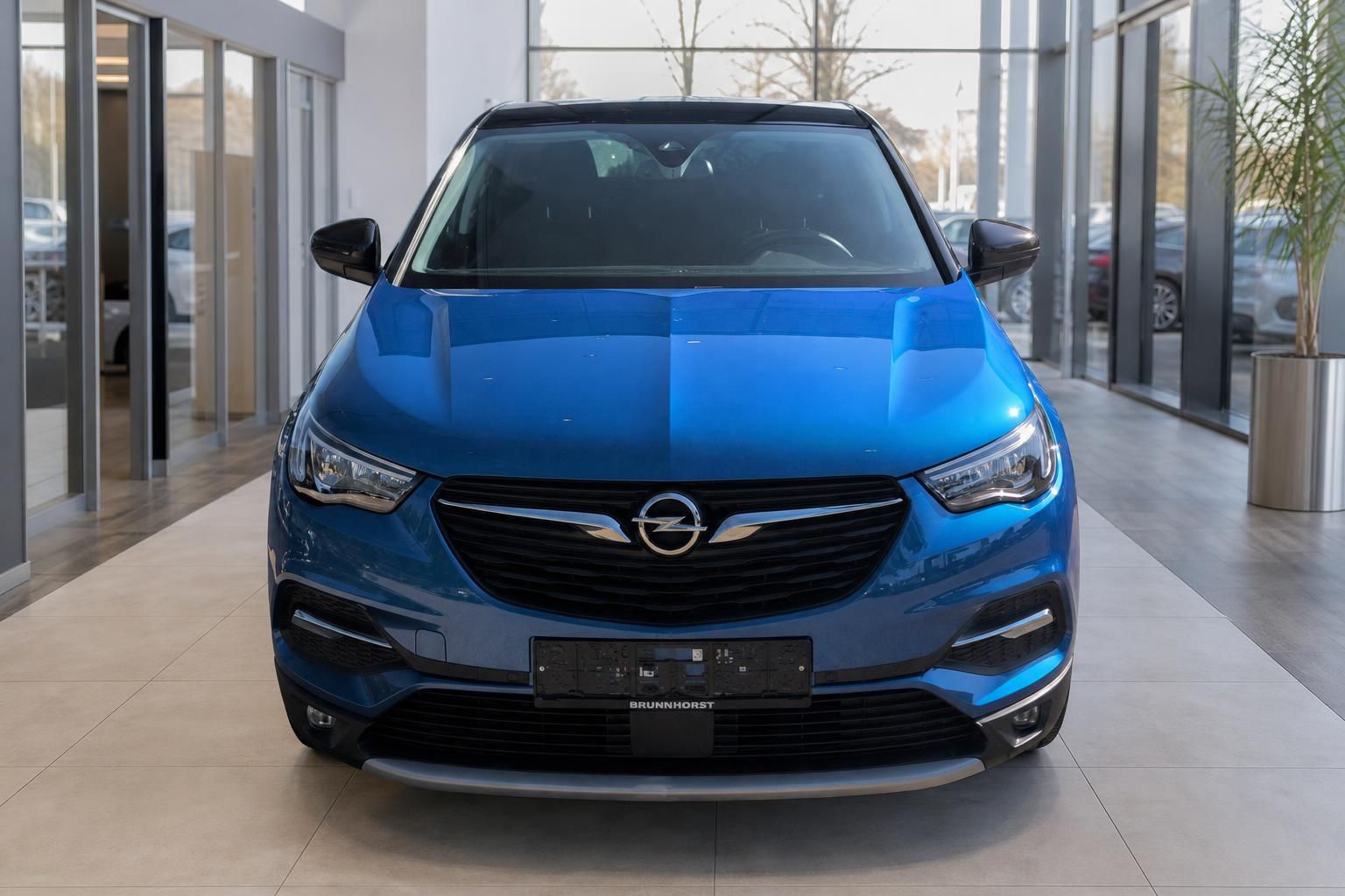 Blauer Opel Grandland X Frontansicht im Autohaus Showroom mit schwarzem Dach und Opel-Logo