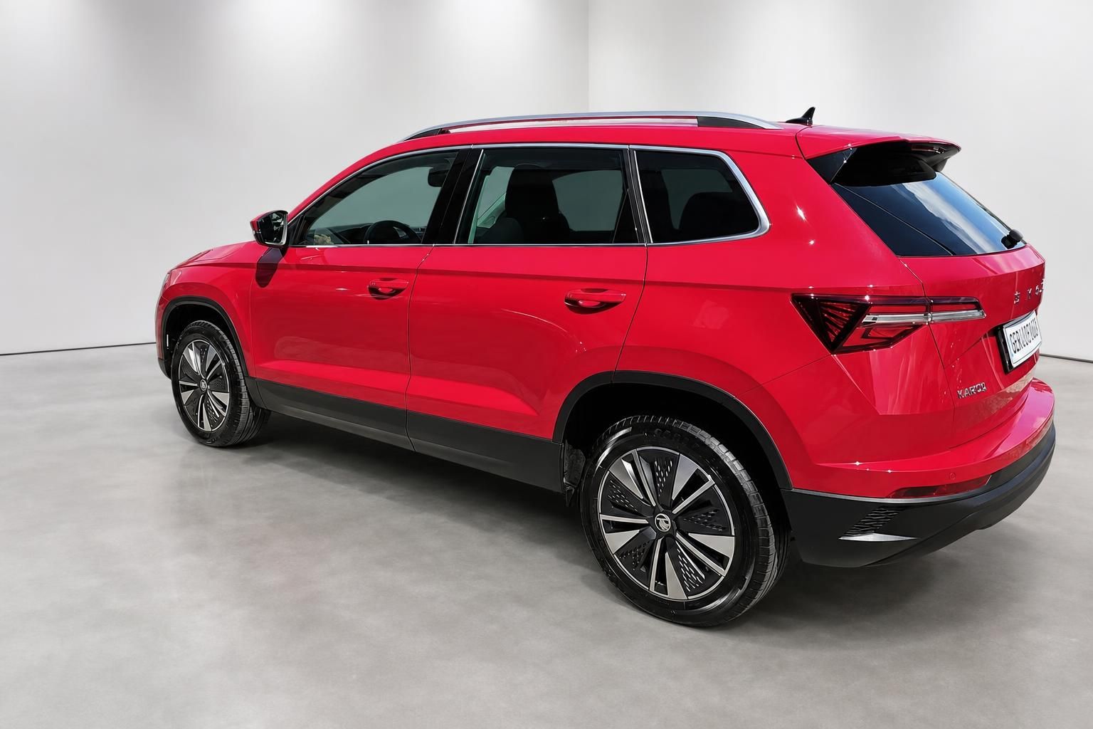 Roter Skoda Karoq Heckansicht schraeg im Studio