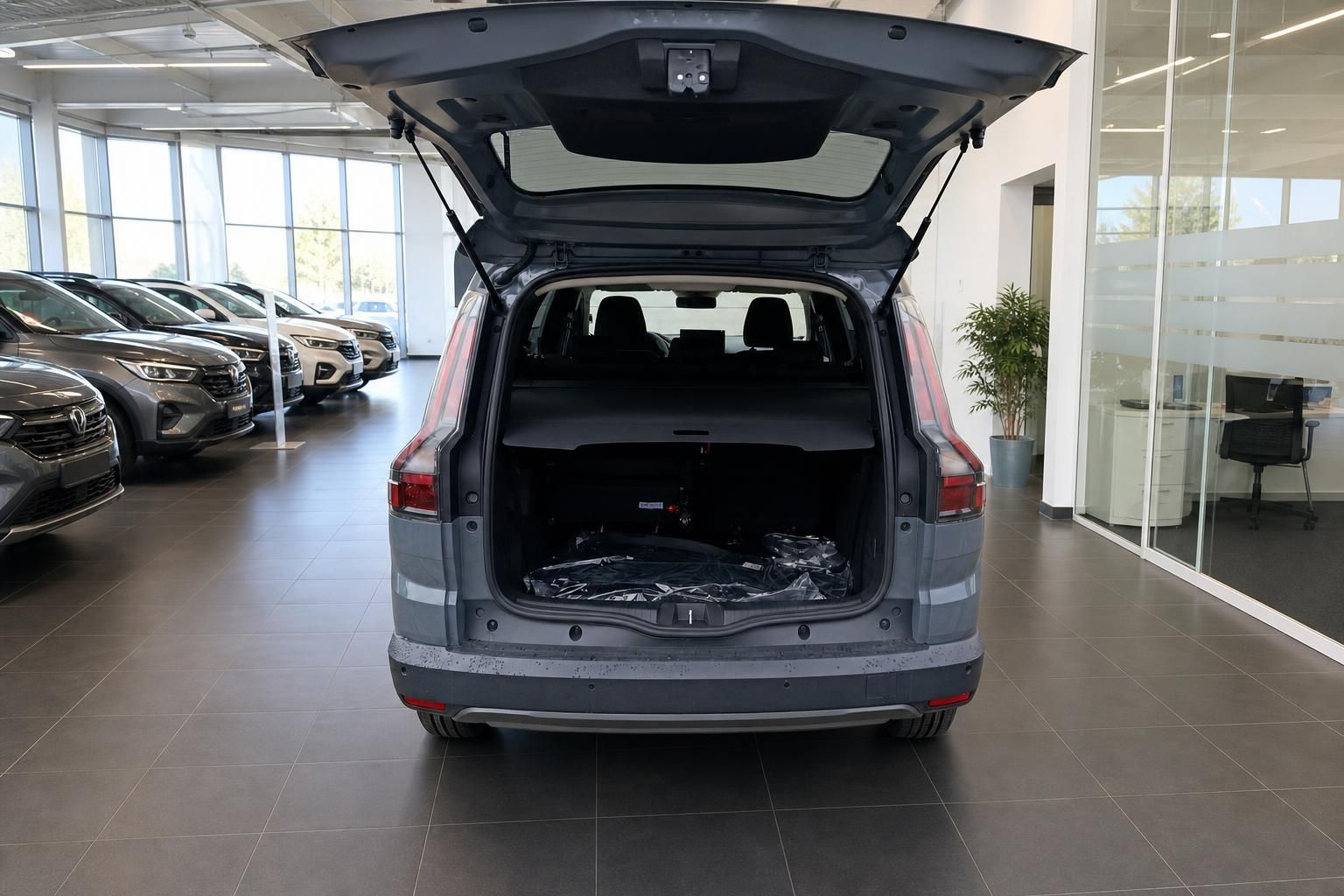 Kofferraum eines grauen SUV mit geoeffneter Heckklappe im Autohaus
