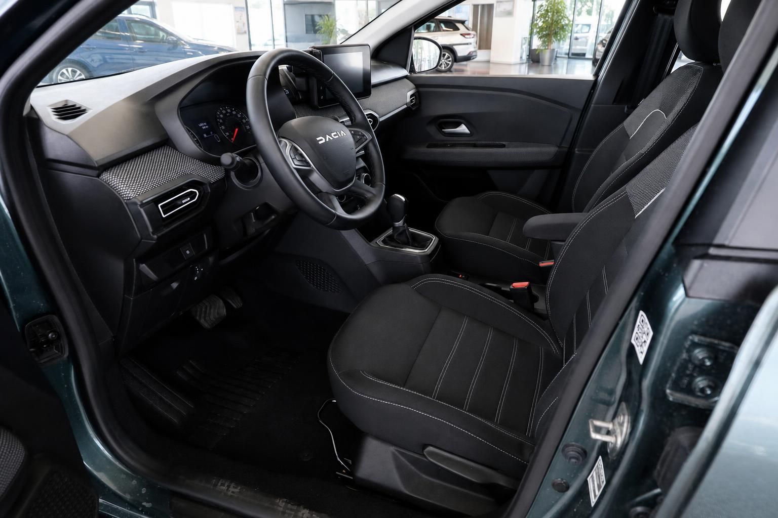 Dacia Innenraum mit schwarzen Sitzen, Lenkrad und Cockpit im Detail