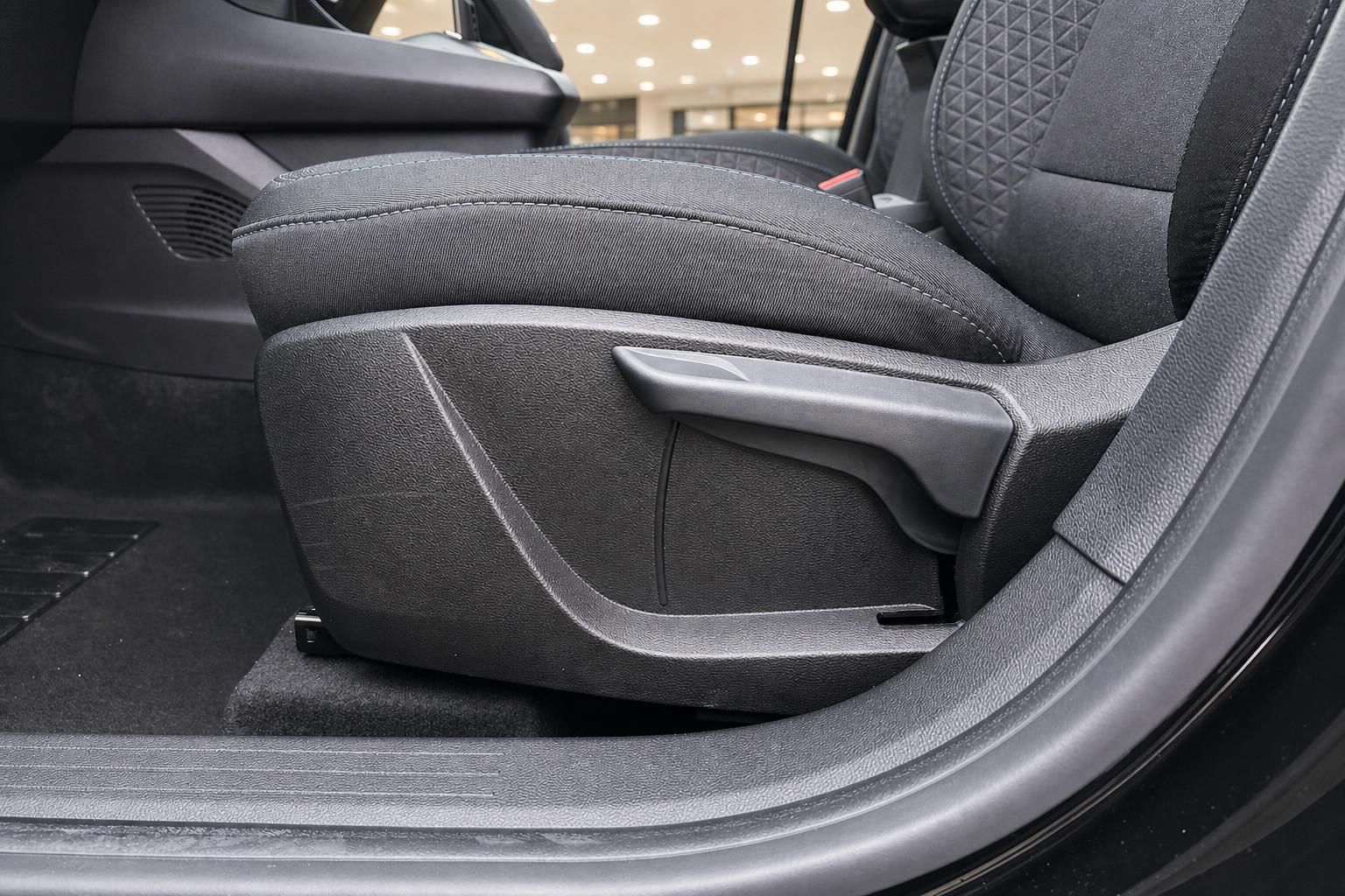 Fahrzeugsitz Detailaufnahme mit Sitzverstellung und schwarzem Alcantara-Stoffbezug im Innenraum