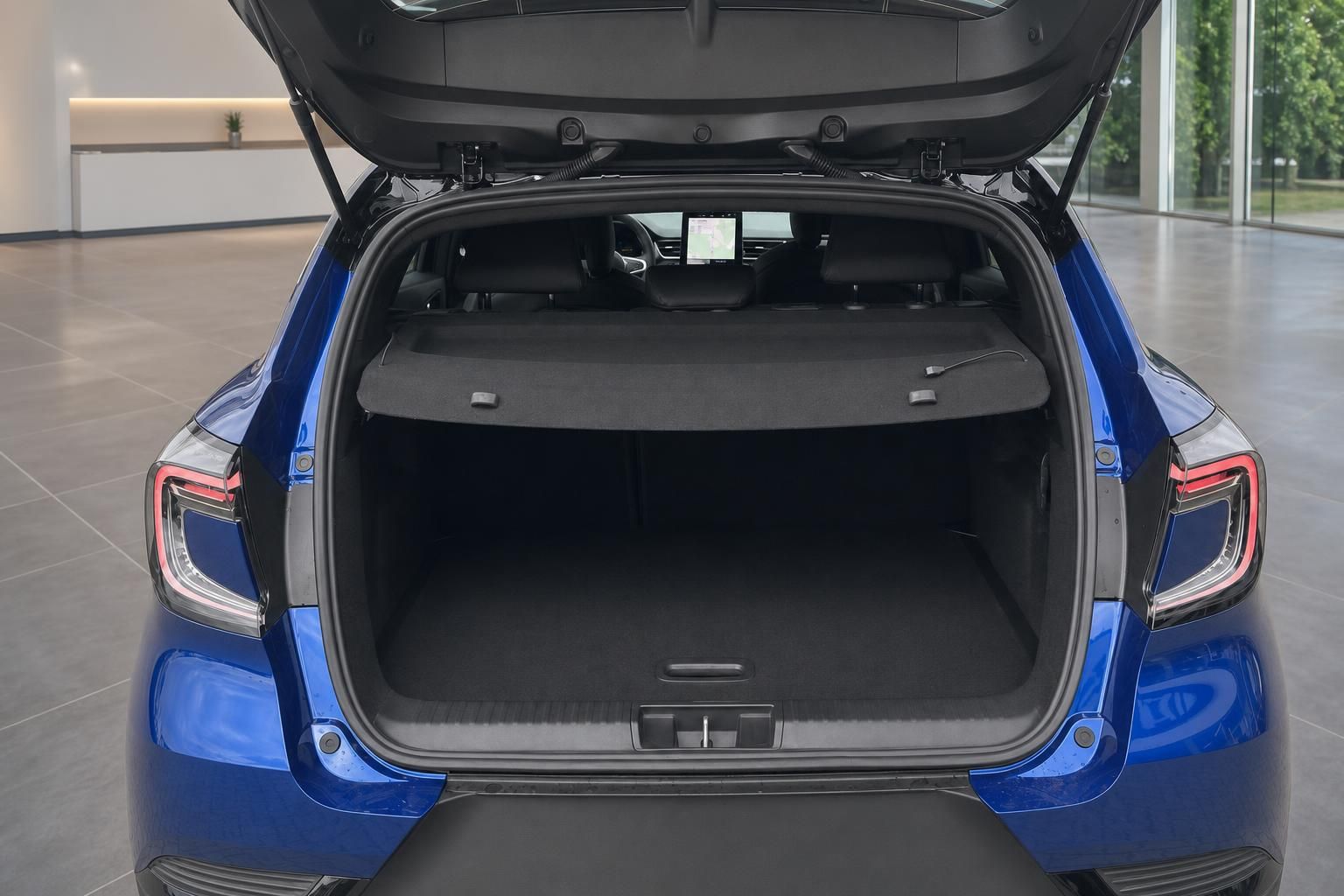 Kofferraum eines blauen Fahrzeugs mit geöffneter Heckklappe und schwarzer Innenausstattung