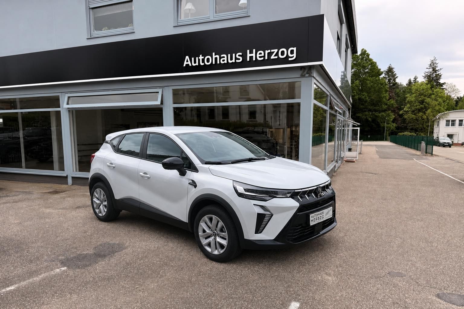 Weißer Mitsubishi SUV Schrägansicht vorne - moderner Crossover vor Autohaus Herzog