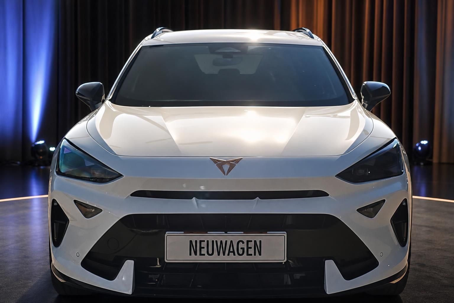 CUPRA Tavascan weiss Frontansicht mit NEUWAGEN-Kennzeichen im Showroom