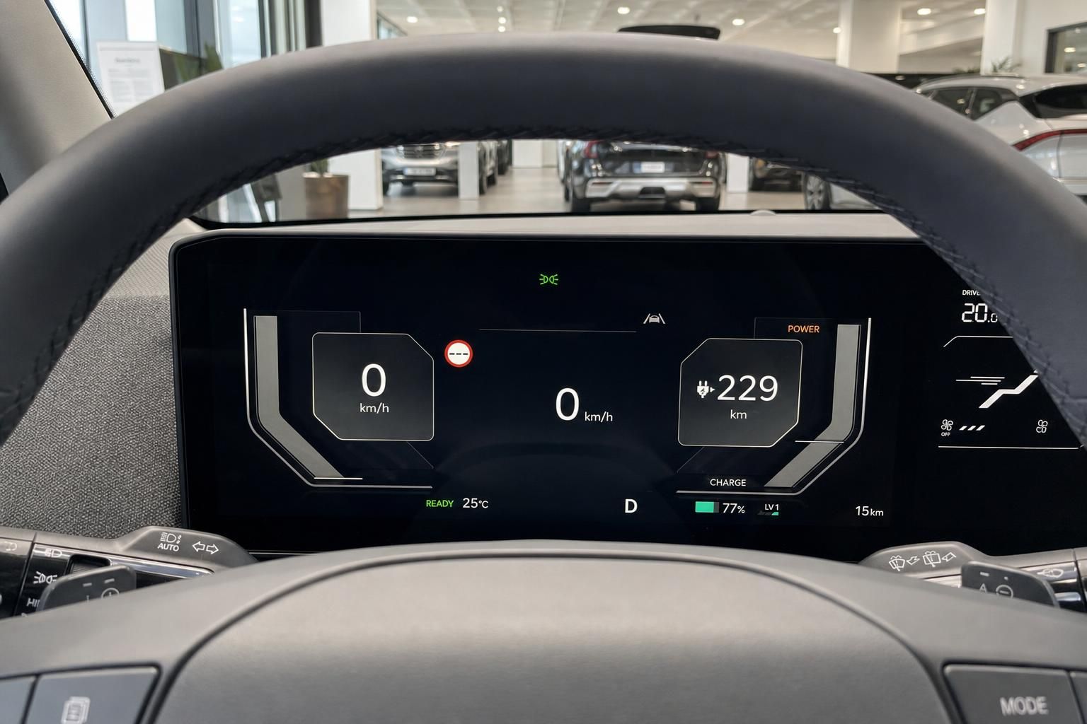 Digitales Cockpit mit Tacho und Reichweitenanzeige hinter dem Lenkrad