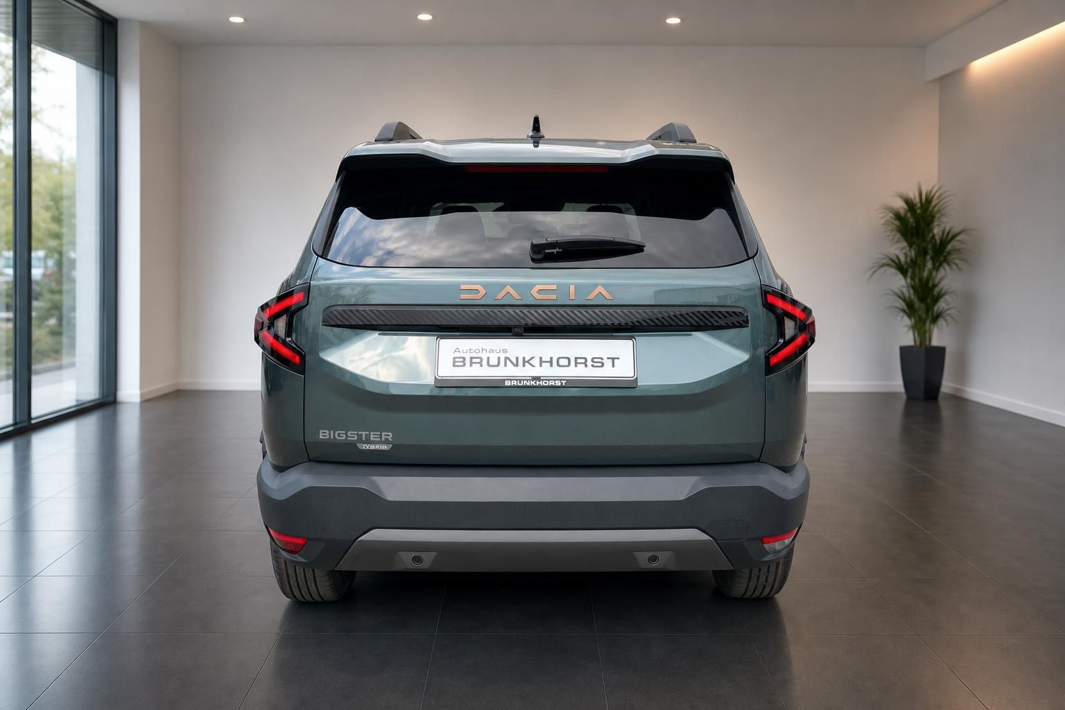 Dacia Bigster Heckansicht in grün metallic im modernen Autohaus Showroom