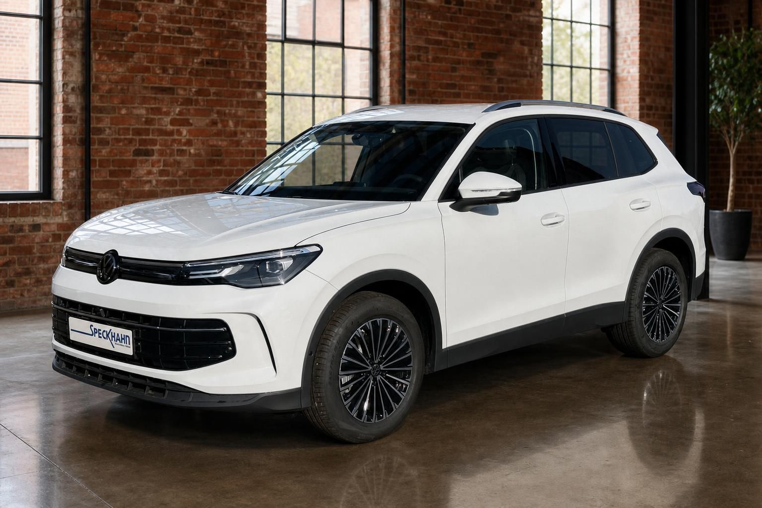 VW Tiguan weiß Frontansicht seitlich vor Backsteinwand