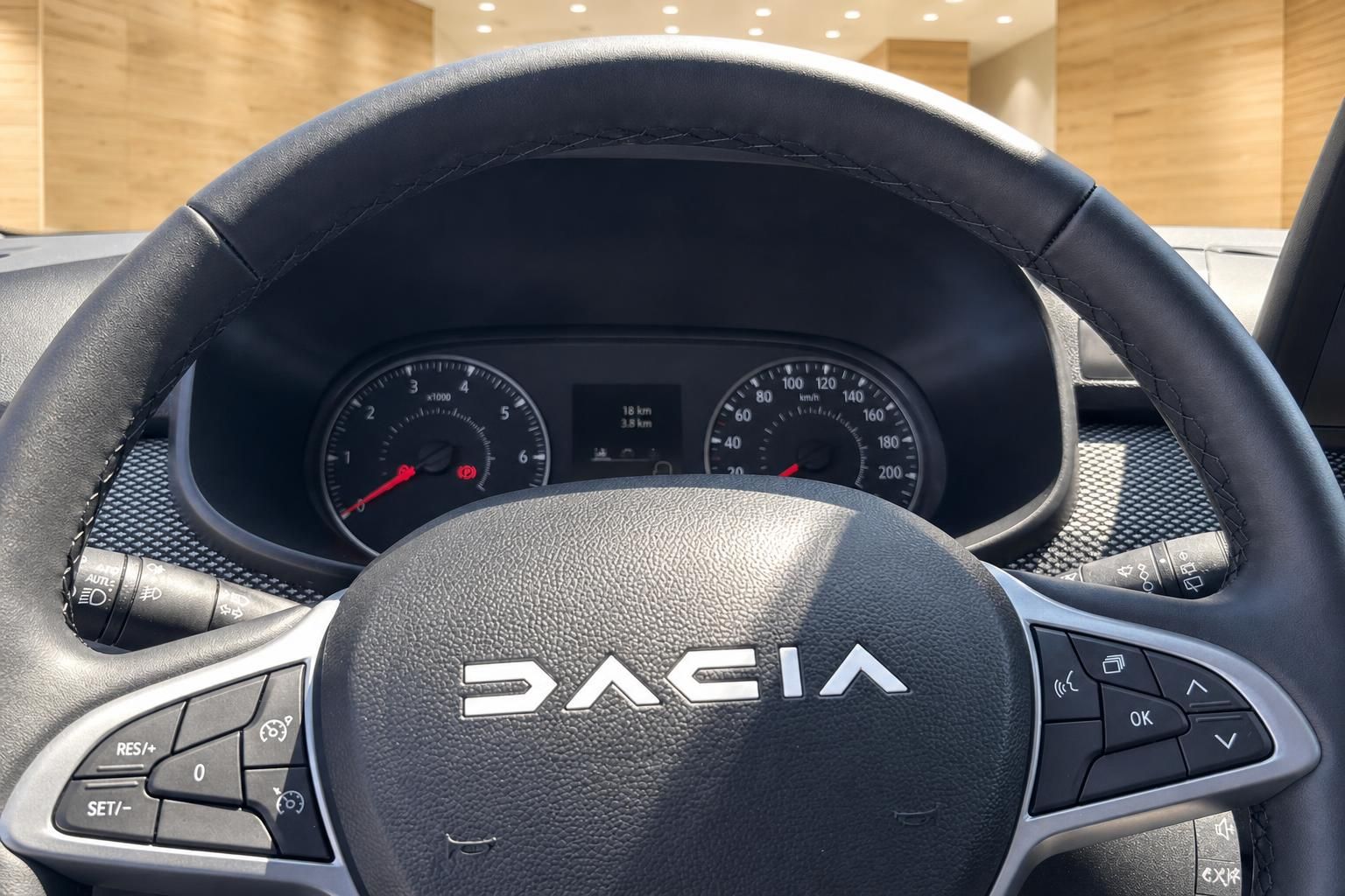 Dacia Lenkrad Nahaufnahme mit Logo, Kombiinstrument mit Tacho und Drehzahlmesser im Hintergrund