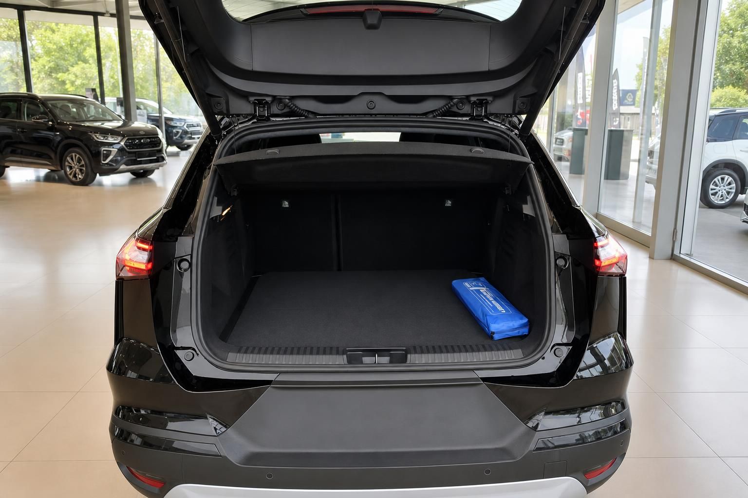 Geöffneter Kofferraum eines dunklen SUV im Autohaus-Showroom mit geräumigem Laderaum