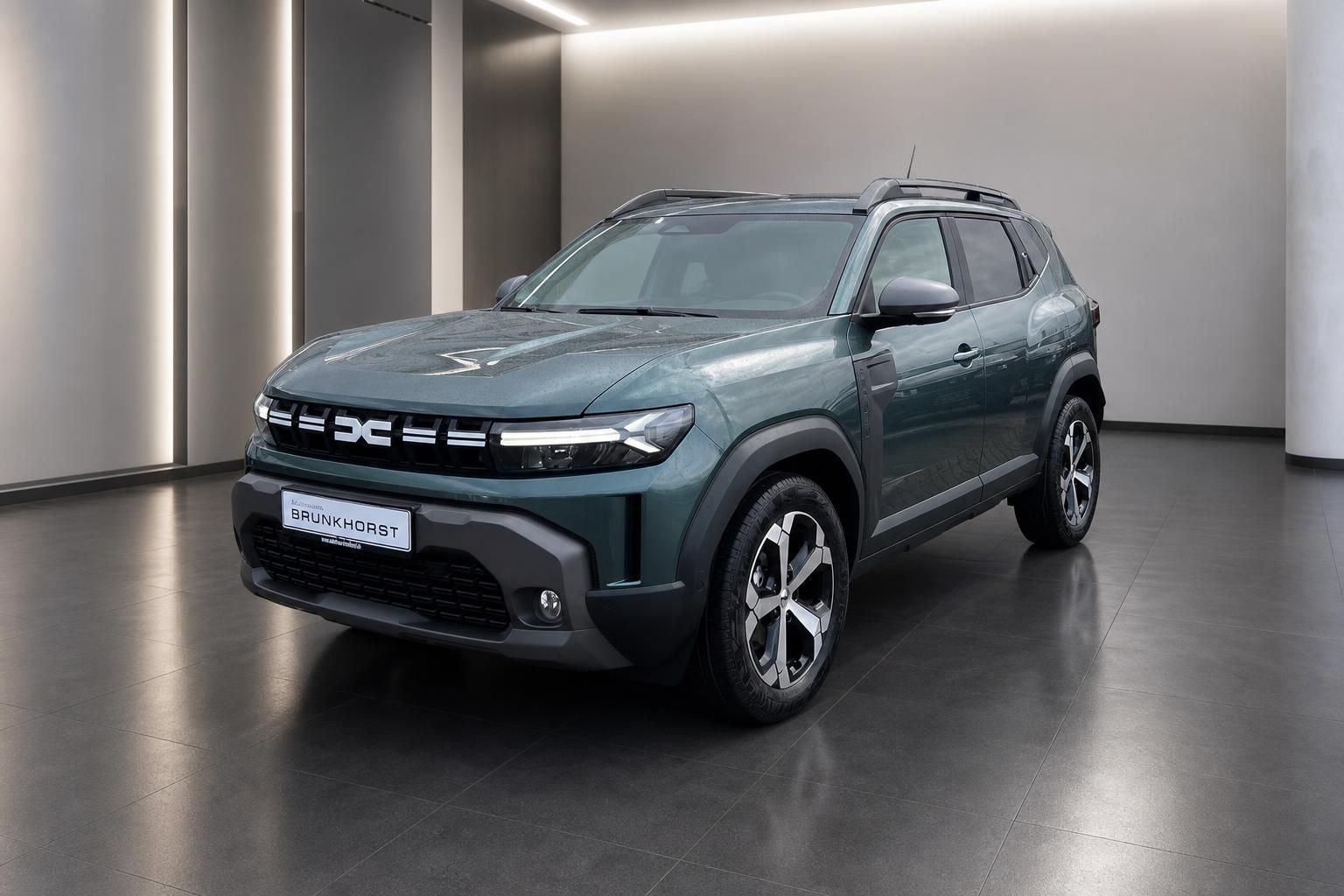 Dacia SUV Seitenansicht grau metallic mit Dachreling im eleganten Showroom