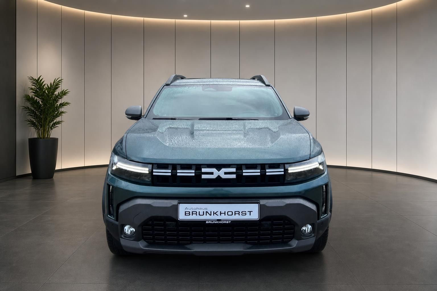 Dacia SUV Frontansicht grau metallic mit LED-Scheinwerfern im modernen Autohaus