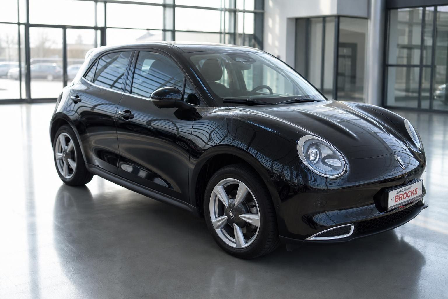 Schwarzer Elektro-Kleinwagen ORA Frontansicht schräg im Autohaus Showroom