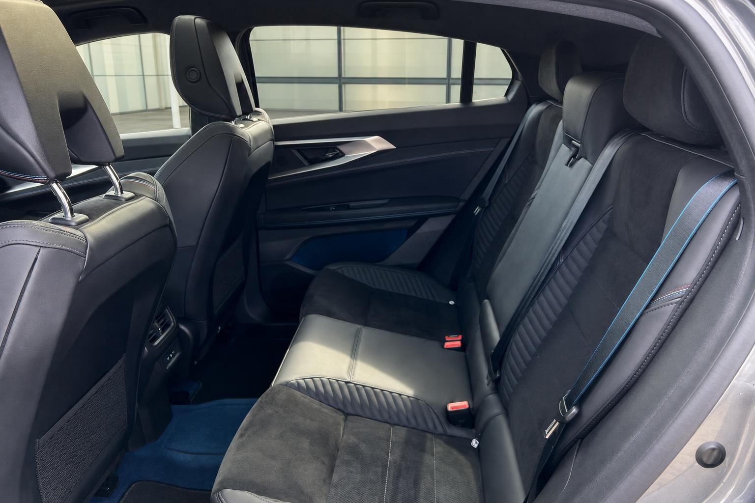 Rücksitzbereich PKW mit dunklen Ledersitzen und blauen Akzenten im Innenraum