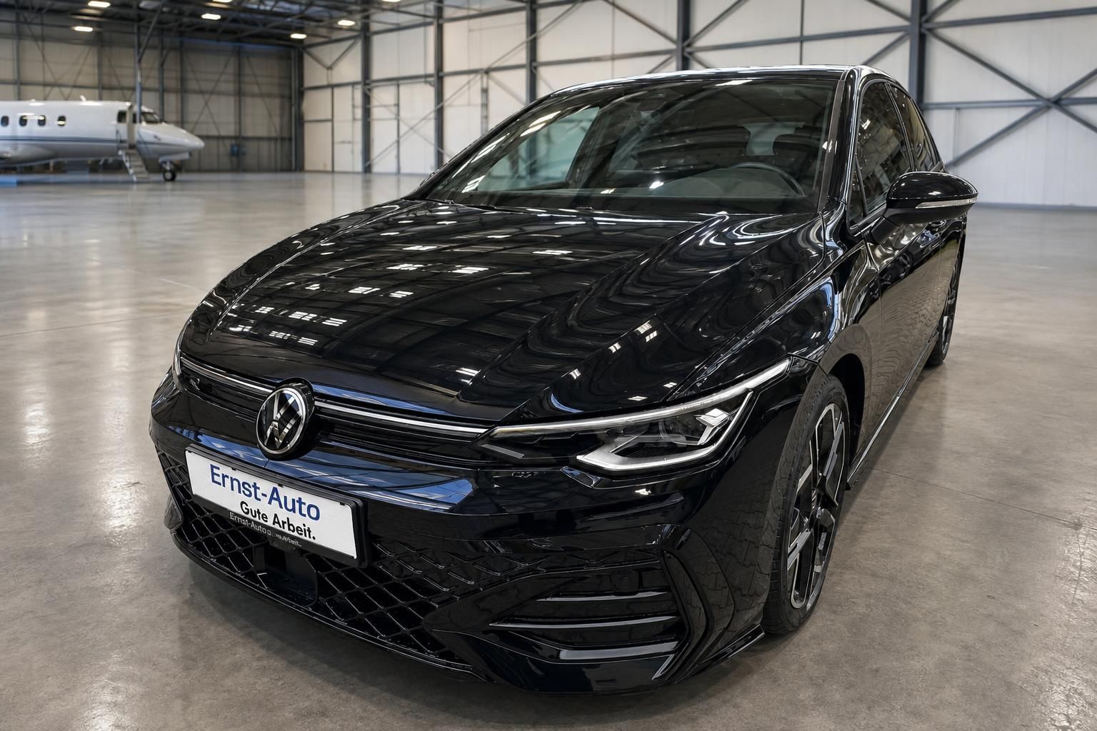 Schwarzer Volkswagen Golf in Hangar - Frontansicht mit modernem Design und LED-Scheinwerfern