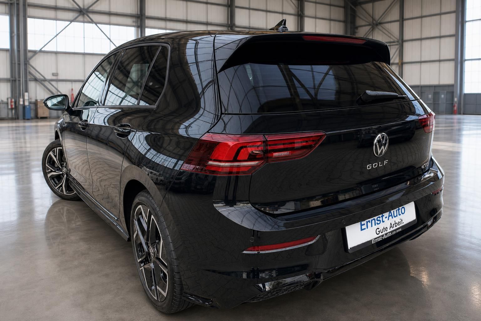 Volkswagen Golf schwarz - Heckansicht mit modernen LED-Rückleuchten in der Ausstellungshalle