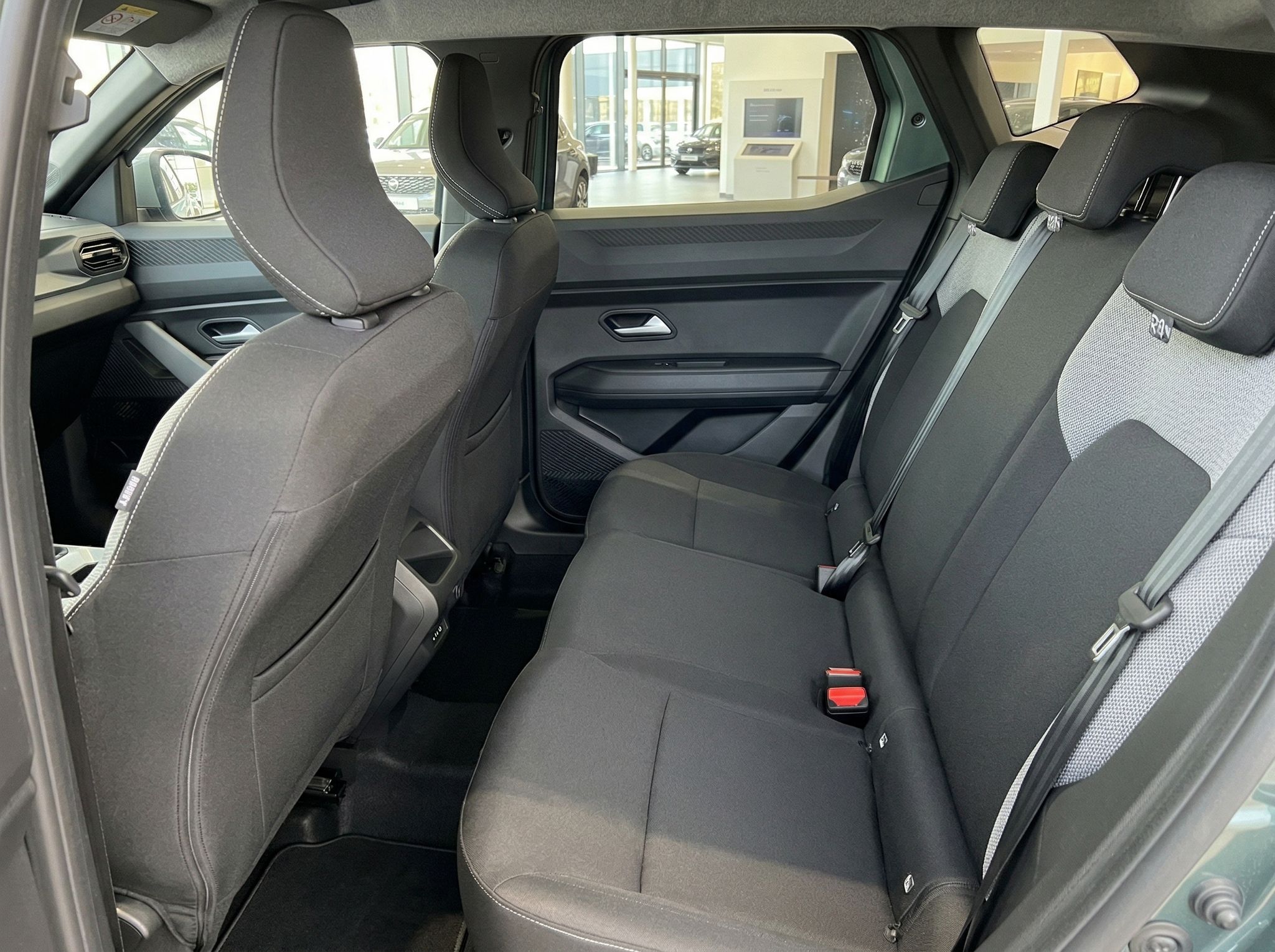 Rücksitzbank mit drei Sitzplätzen und Sicherheitsgurten im Fahrzeuginnenraum