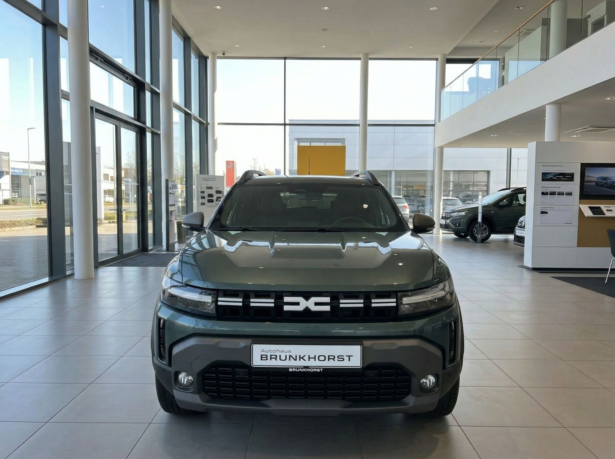 Dacia SUV Frontansicht in grauer Metallic-Lackierung im modernen Autohaus Showroom