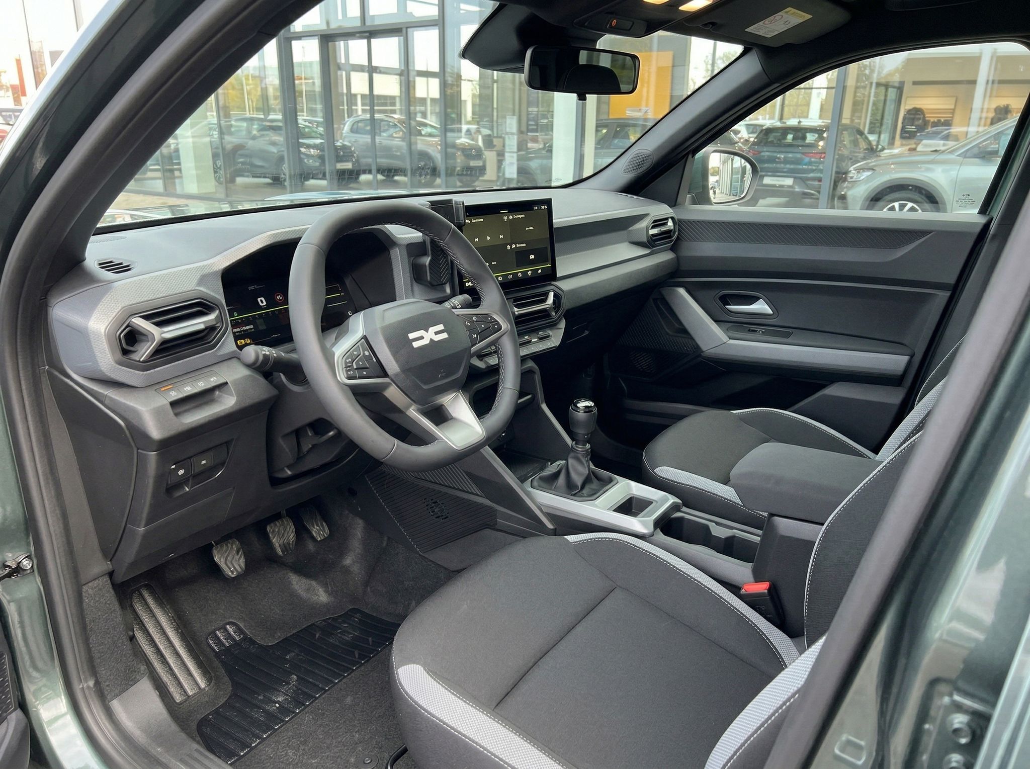 Dacia Fahrzeug Innenraum mit schwarzem Interieur, Lenkrad und modernem Infotainment-Display