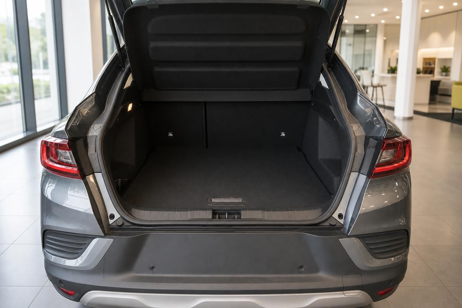 Geräumiger Kofferraum eines grauen SUV-Coupés mit geöffneter Heckklappe im Autohaus